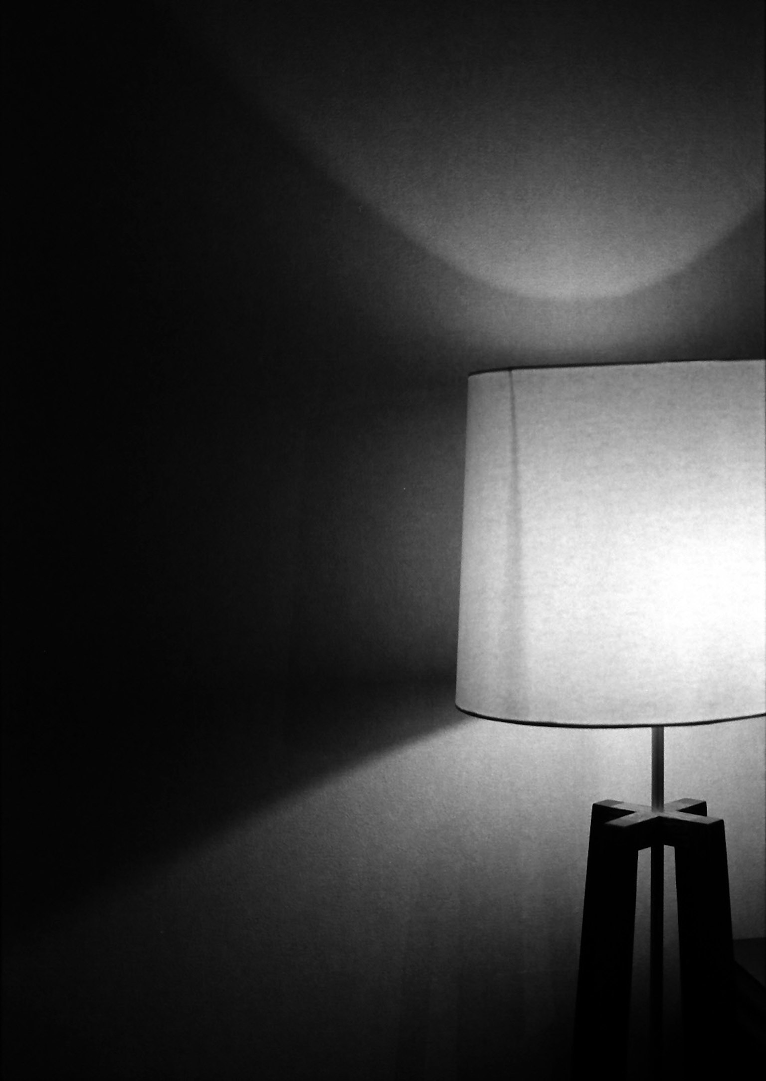 Image en noir et blanc d'une lampe blanche projetant des ombres
