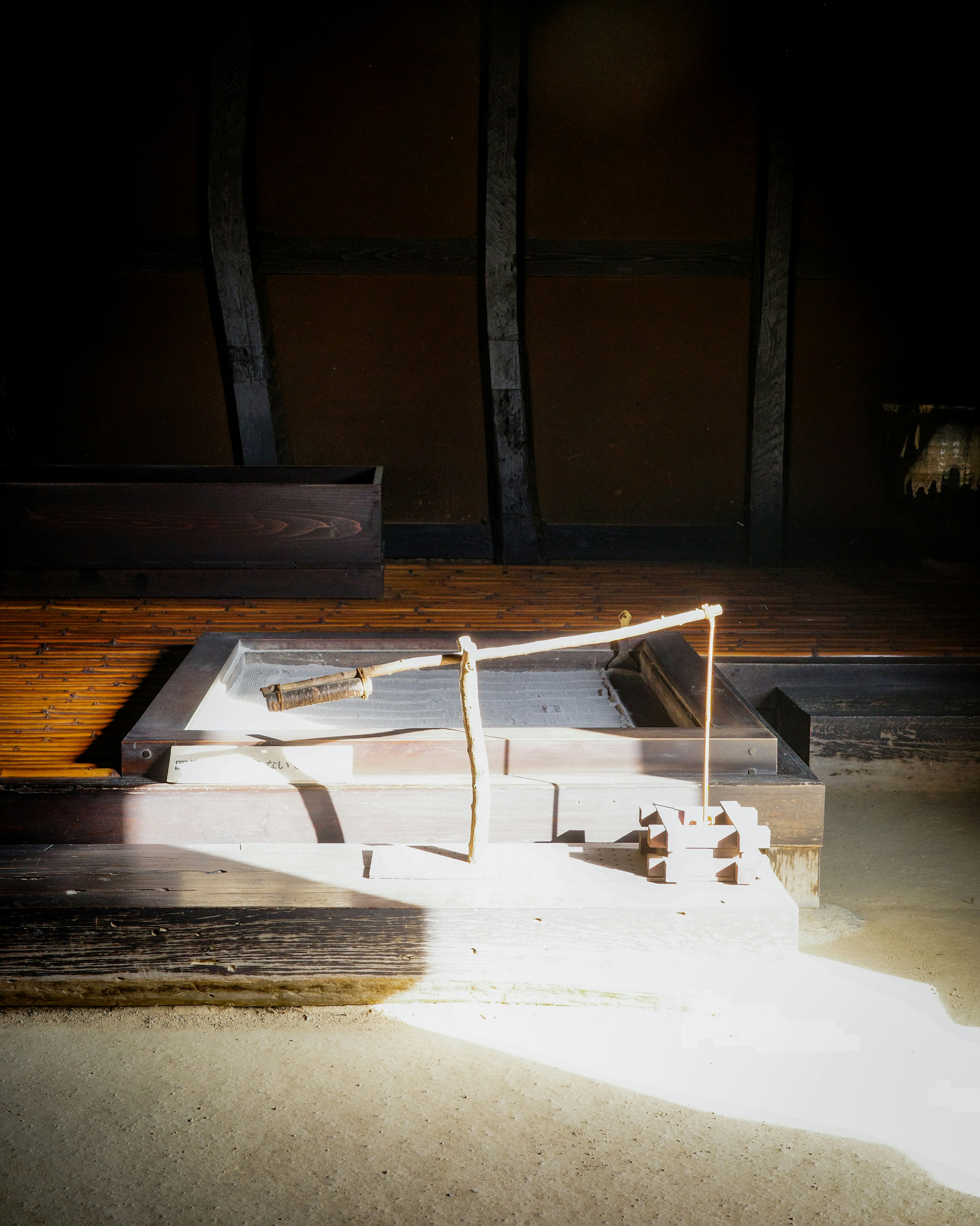 A scale model on a gallery floor under focused lighting