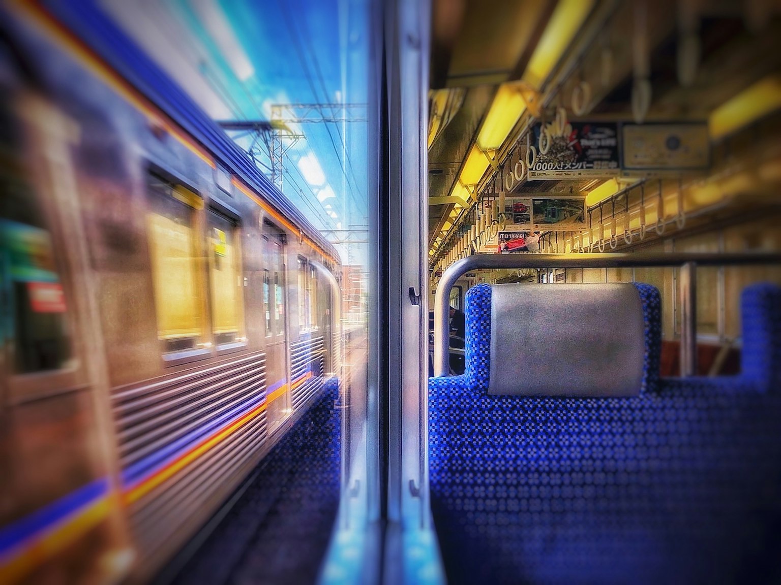 電車の車両内からの視点で外の電車が通過する様子を捉えた画像