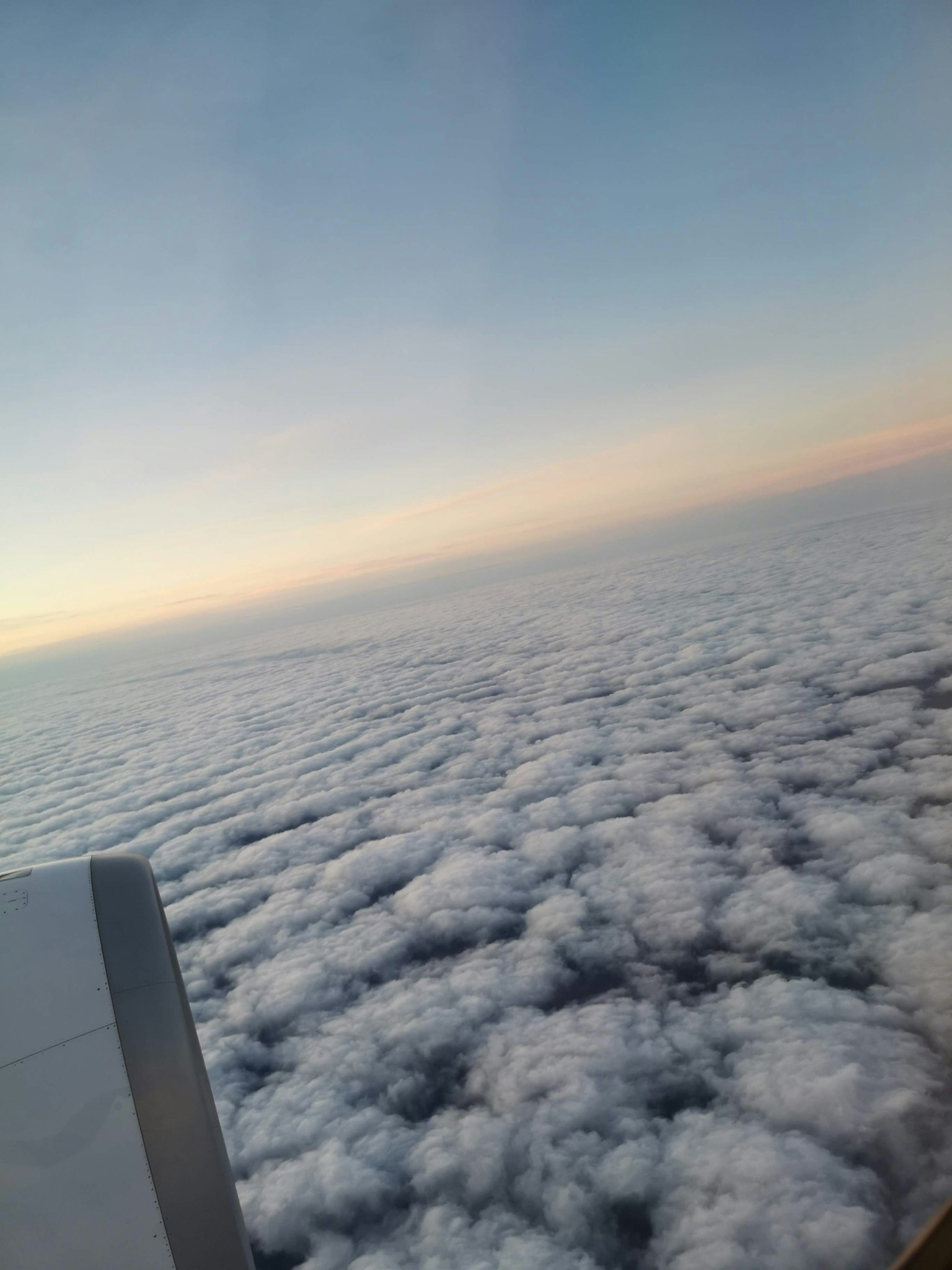 Vue de la mer de nuages et du ciel dégradé depuis la fenêtre de l'avion
