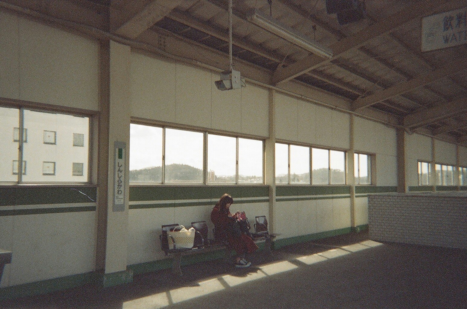 駅の待合室でベンチに座る人と自転車のある風景