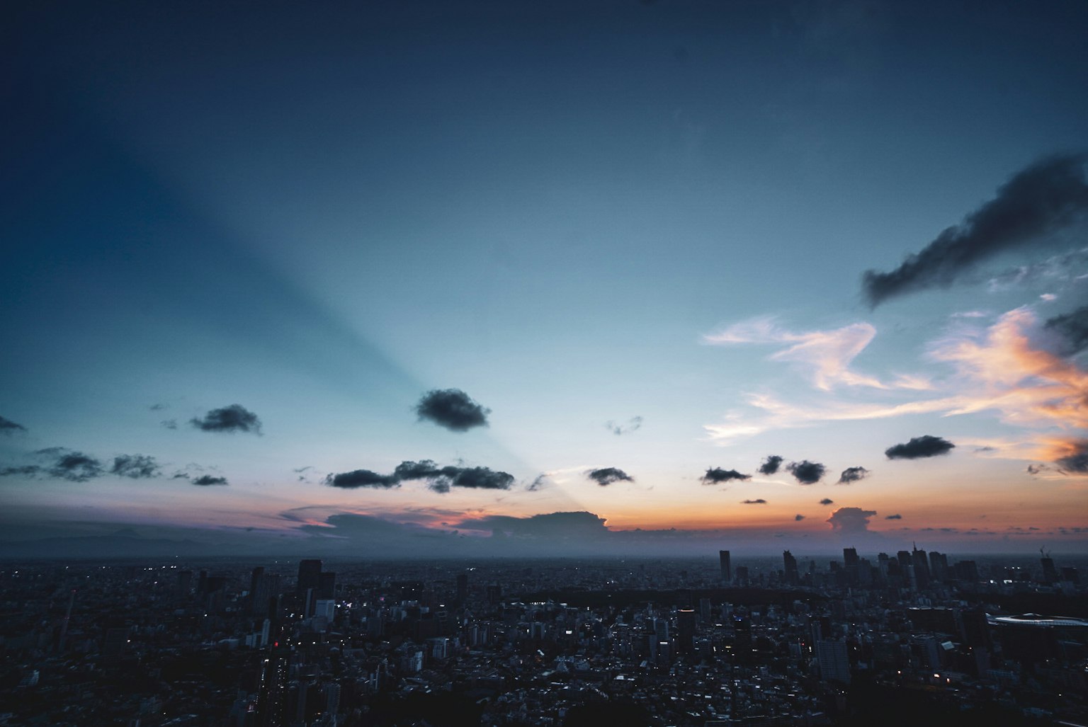 Vista panoramica di un paesaggio urbano sotto un cielo al tramonto con nuvole