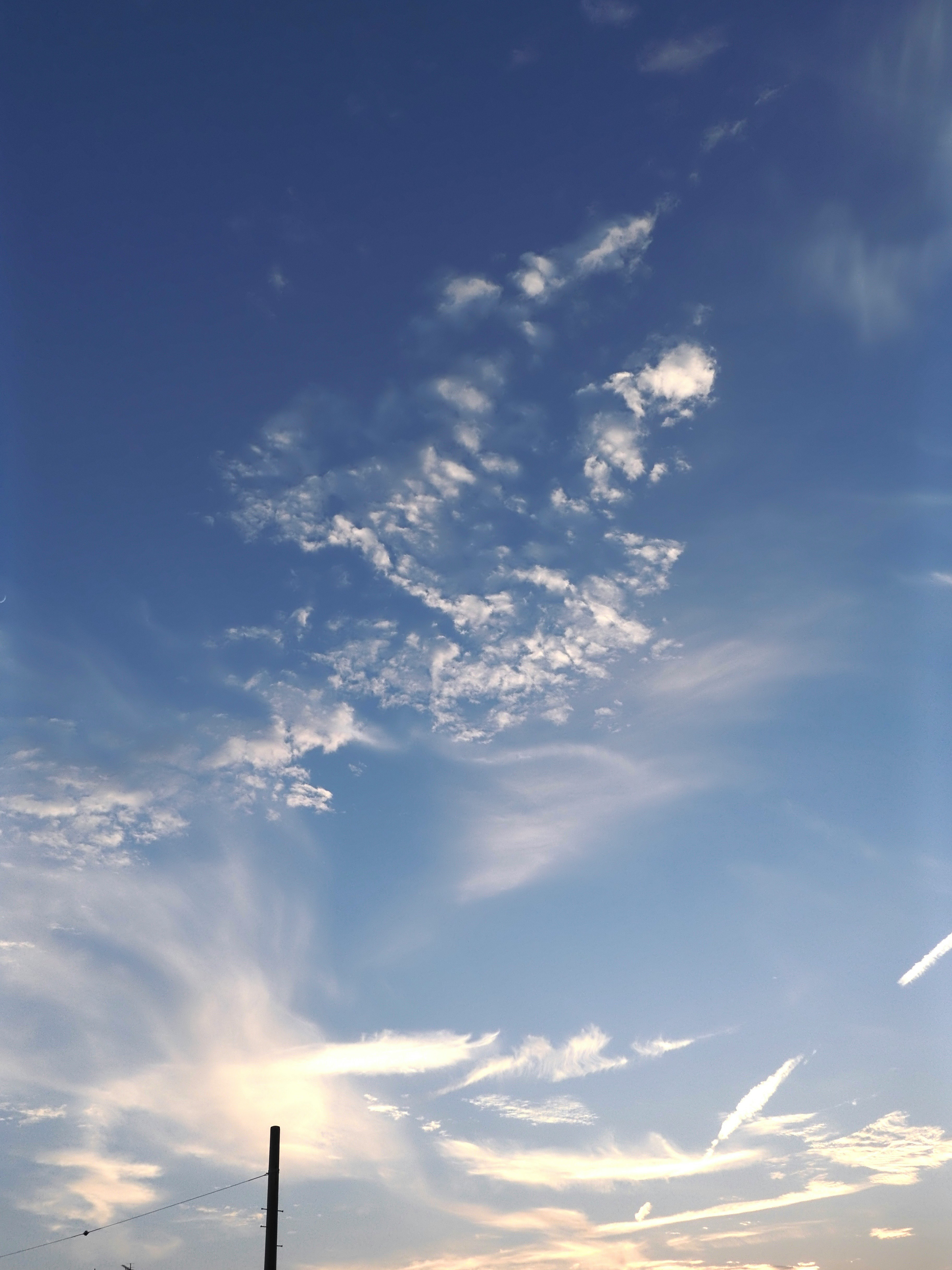 青空に浮かぶ雲と夕焼けの光