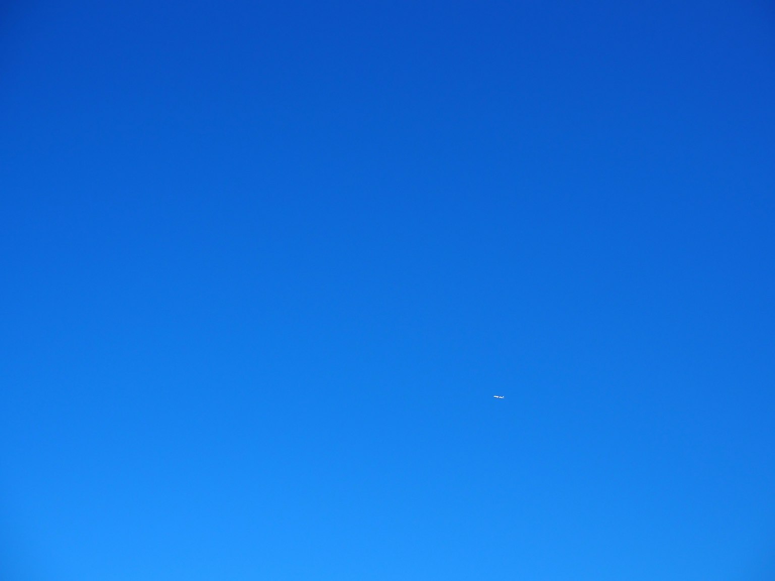 Un cielo blu chiaro con un piccolo punto bianco