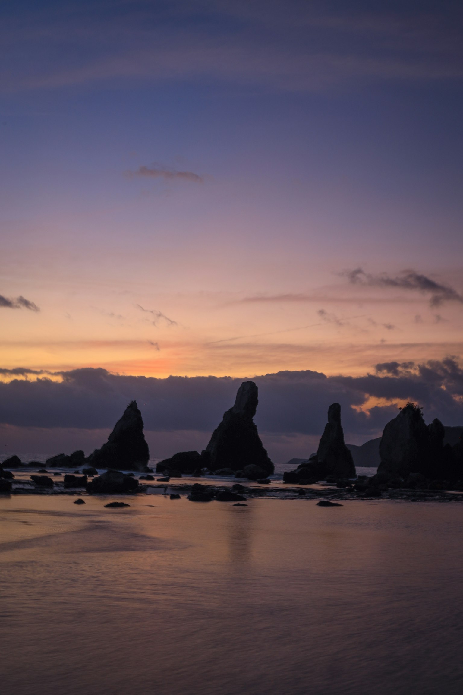 Silhouette von Felsen bei Sonnenuntergang am Strand