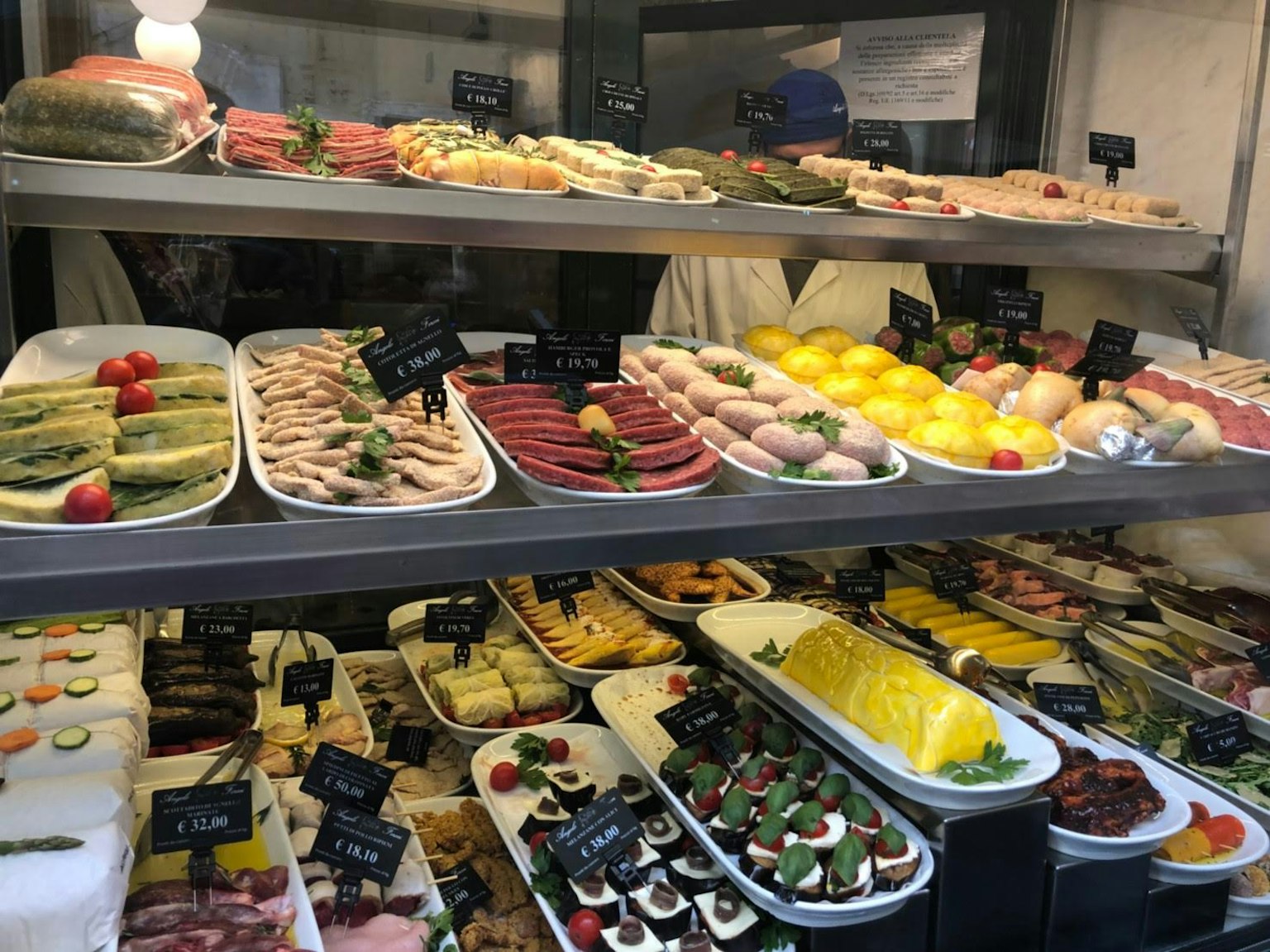 Una vetrina di gastronomia piena di piatti colorati e prelibatezze