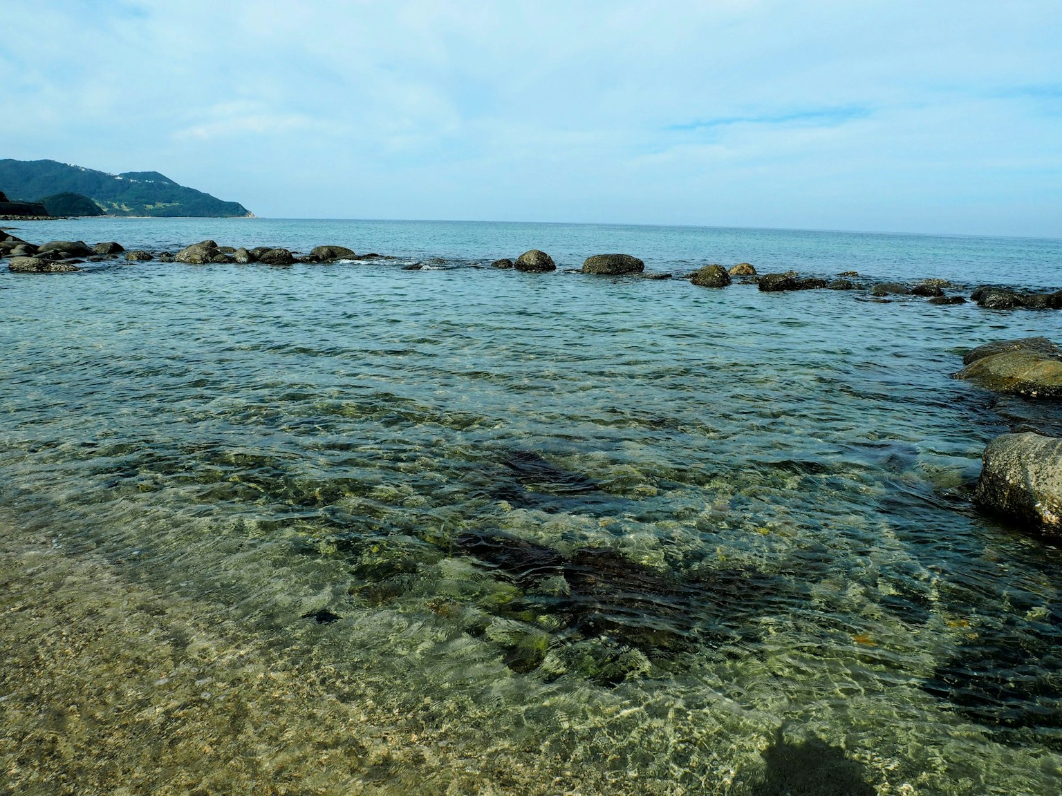 Vista panoramica di una spiaggia con acqua limpida e rocce