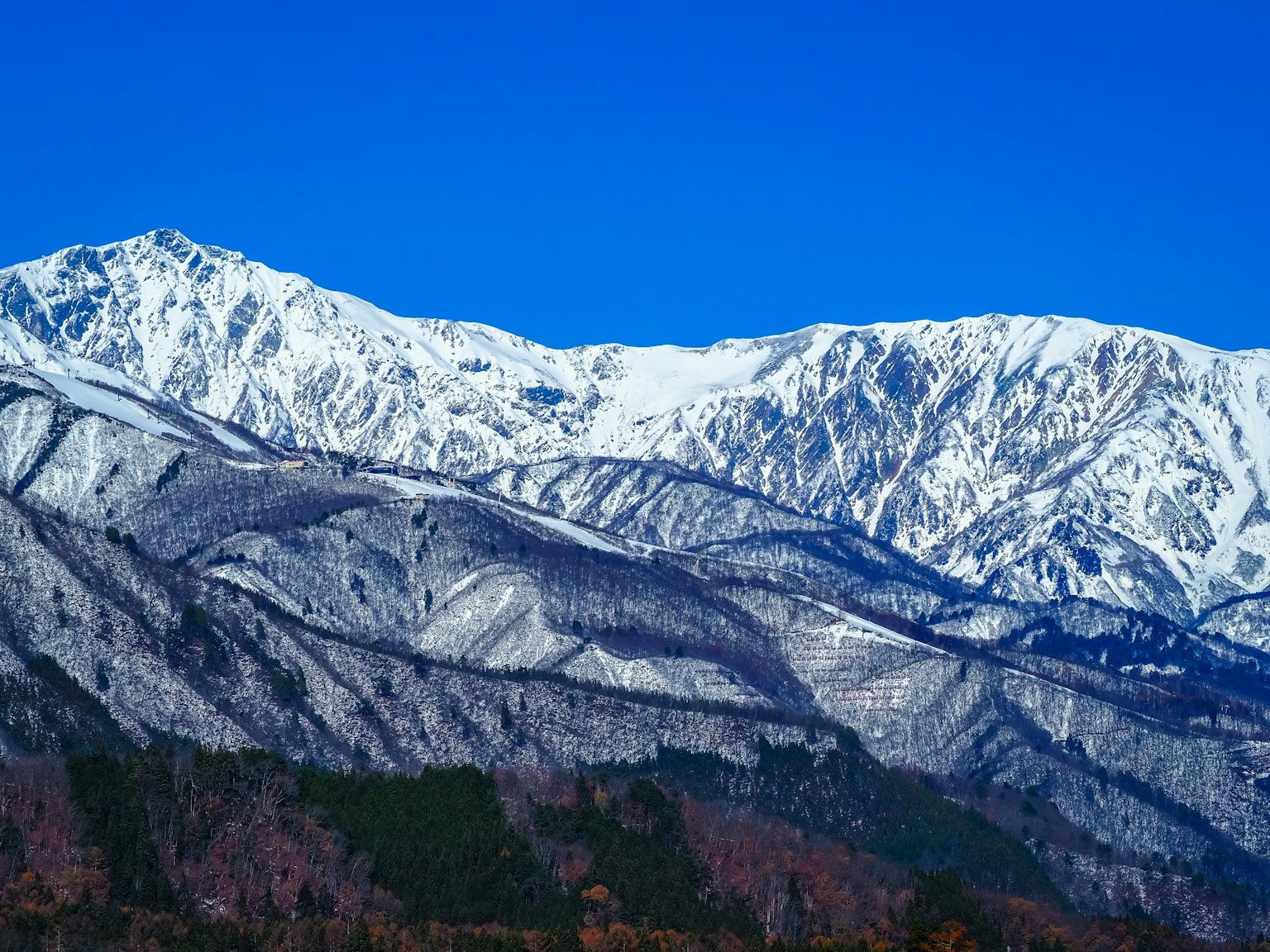 맑은 파란 하늘 아래 눈 덮인 산들