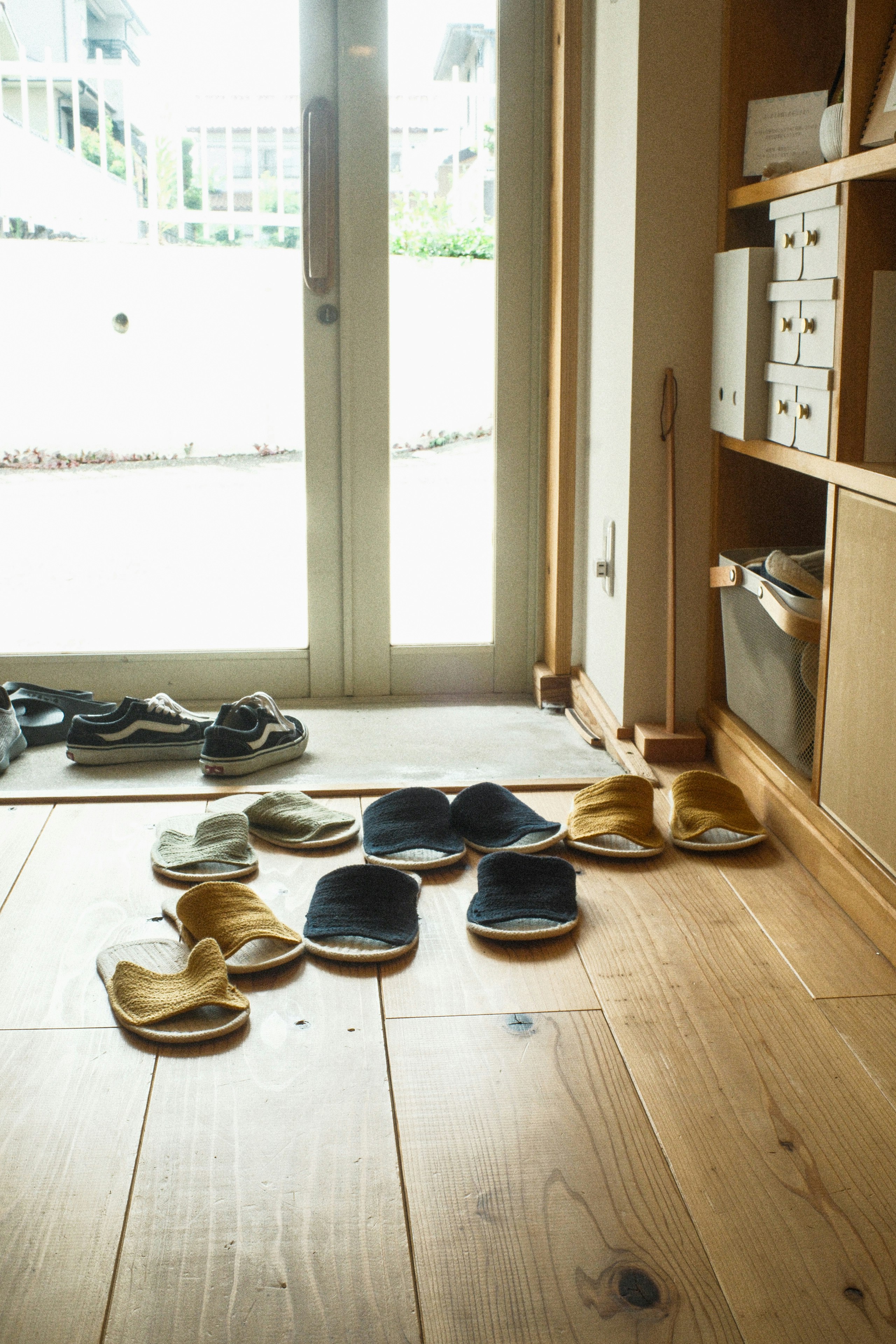 zapatillas y zapatos alineados en el suelo de la entrada