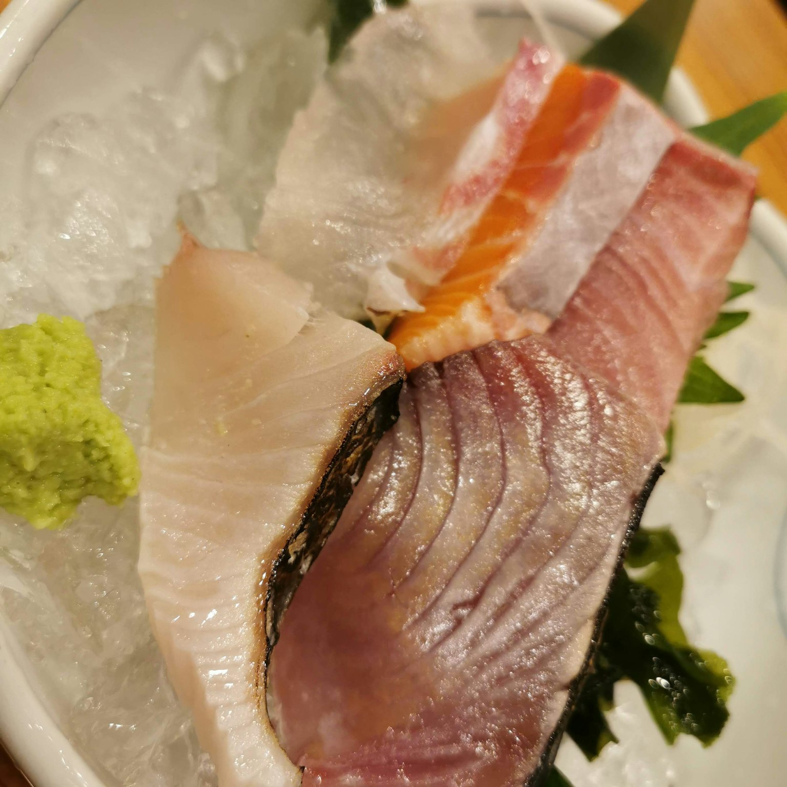 Sashimi segar disusun di atas es dengan wasabi dan hiasan