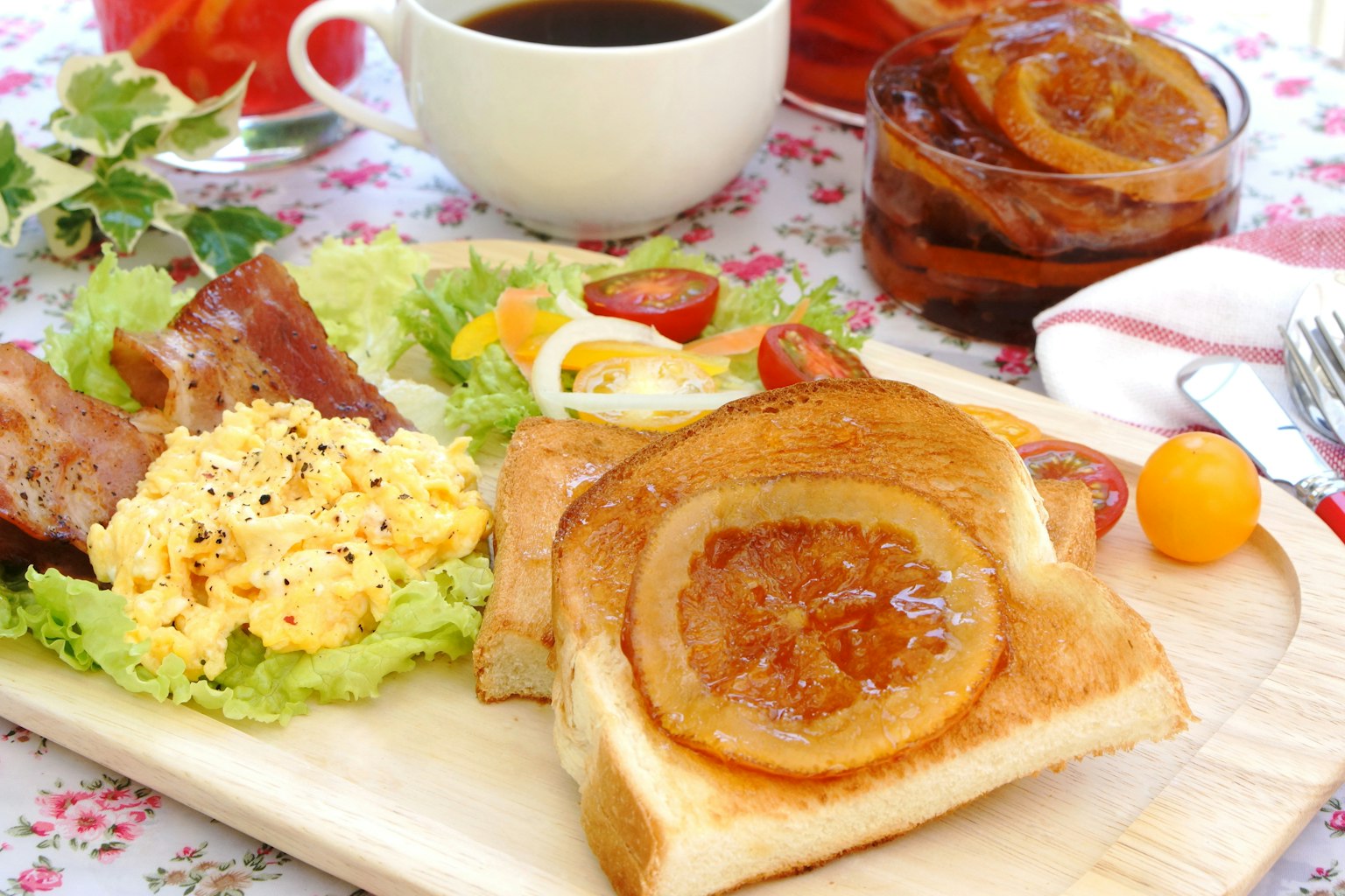 Đĩa ăn sáng với bánh mì nướng mứt cam salad trứng bác và thịt xông khói
