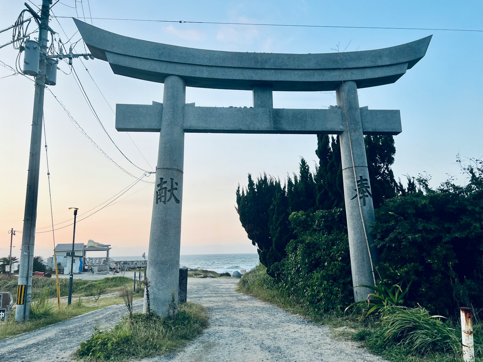Cổng torii đá dẫn đến biển dọc theo con đường yên tĩnh