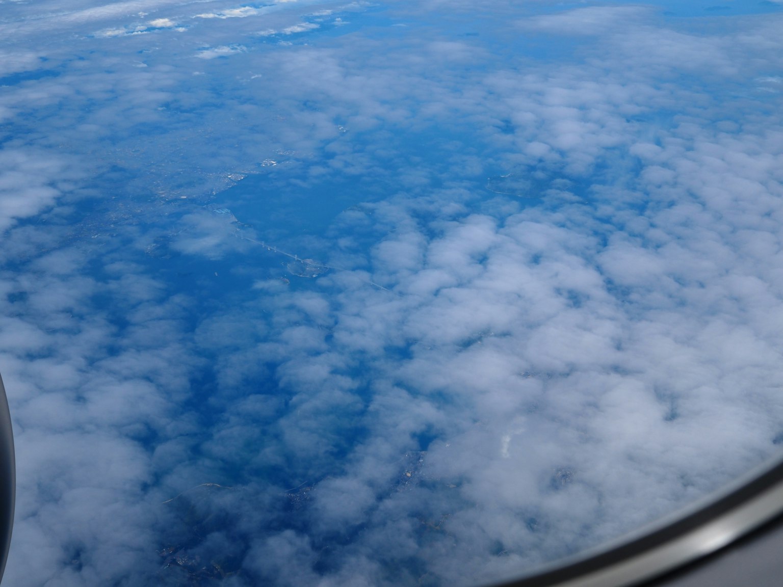 Vue du ciel bleu et des nuages blancs depuis une fenêtre d'avion