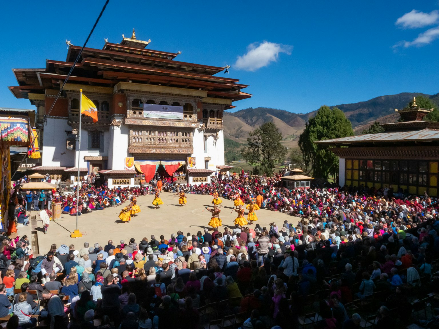 Multitud asistiendo a un festival de danza tradicional frente a un hermoso templo