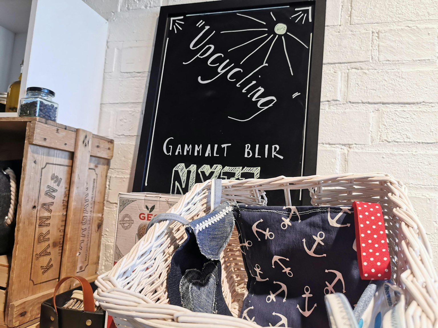 装满手工物品的白色篮子和写着“Upcycling”的黑板