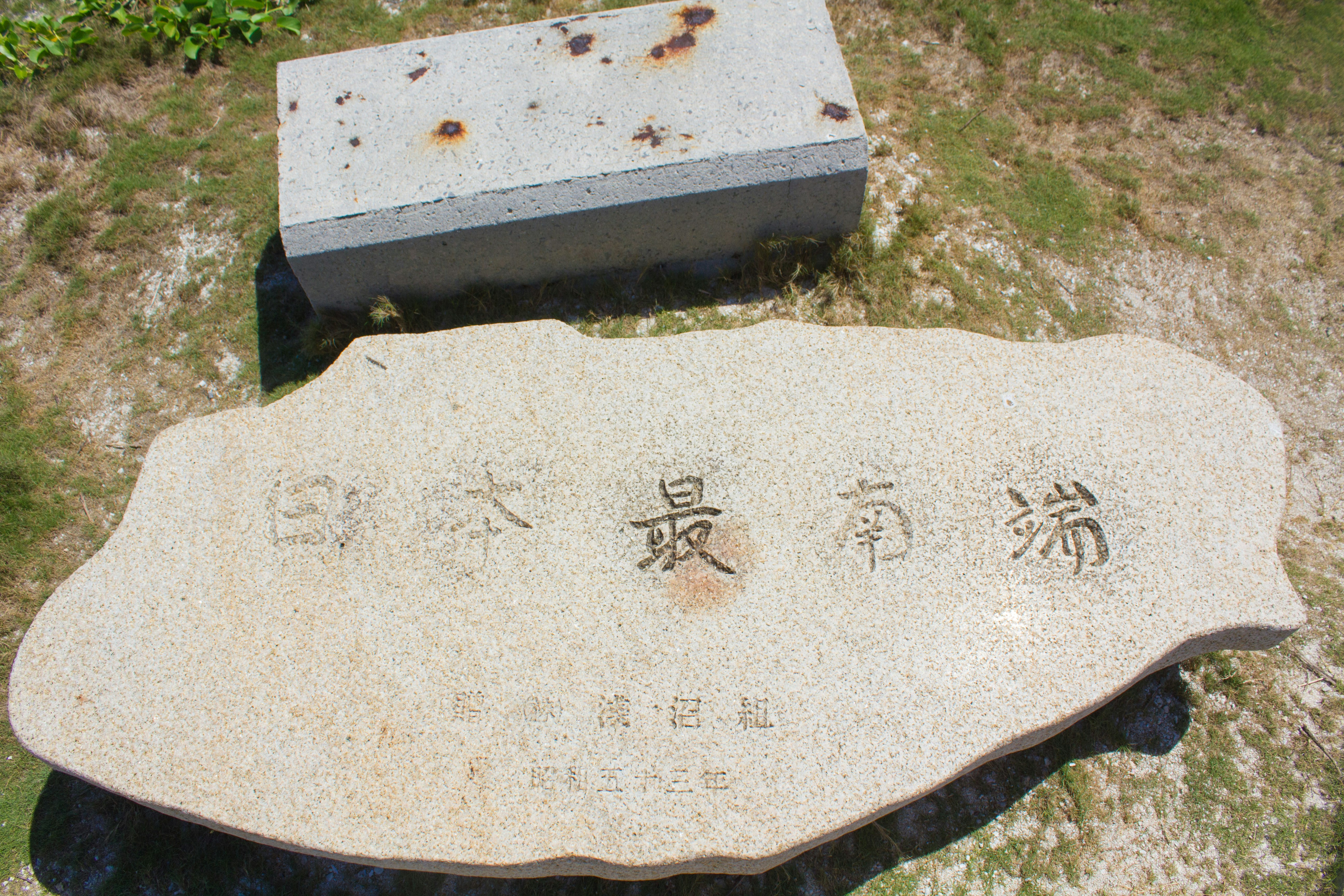 Chinese-inscribed stone marker on grass
