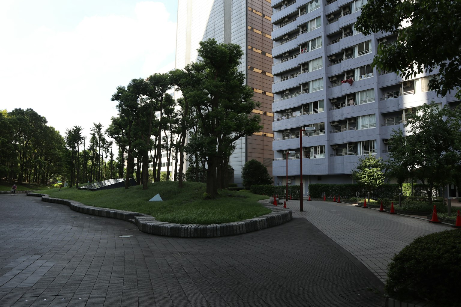 Công viên xanh tươi và lối đi gần tòa nhà cao