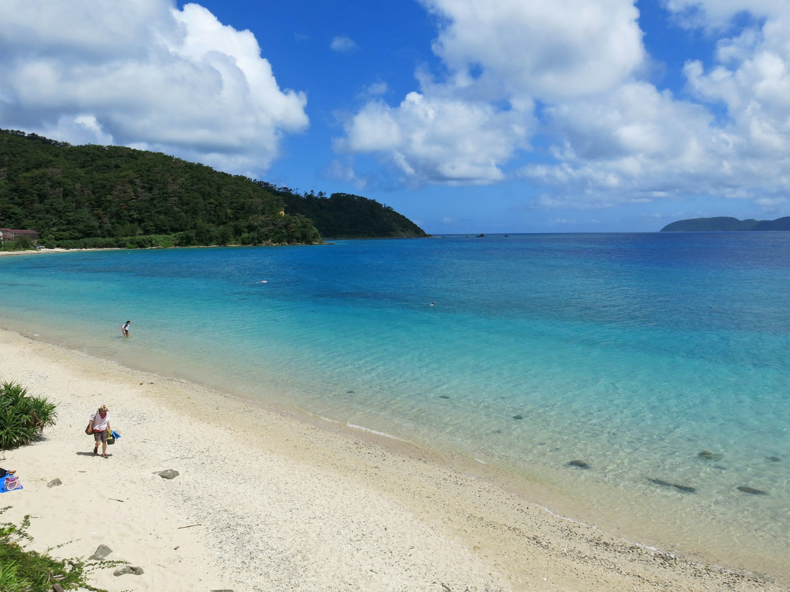 ทิวทัศน์ชายหาดที่มีน้ำสีฟ้าและทรายขาว
