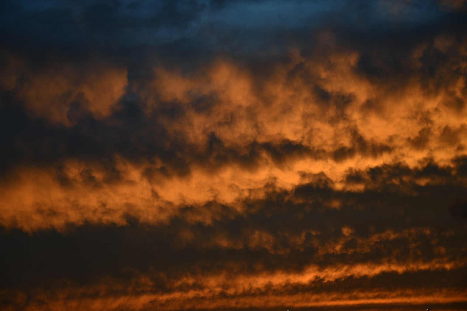 Langit dipenuhi awan oranye saat matahari terbenam