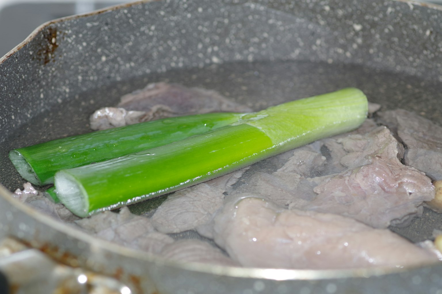 เนื้อและต้นหอมที่กำลังปรุงในหม้อ