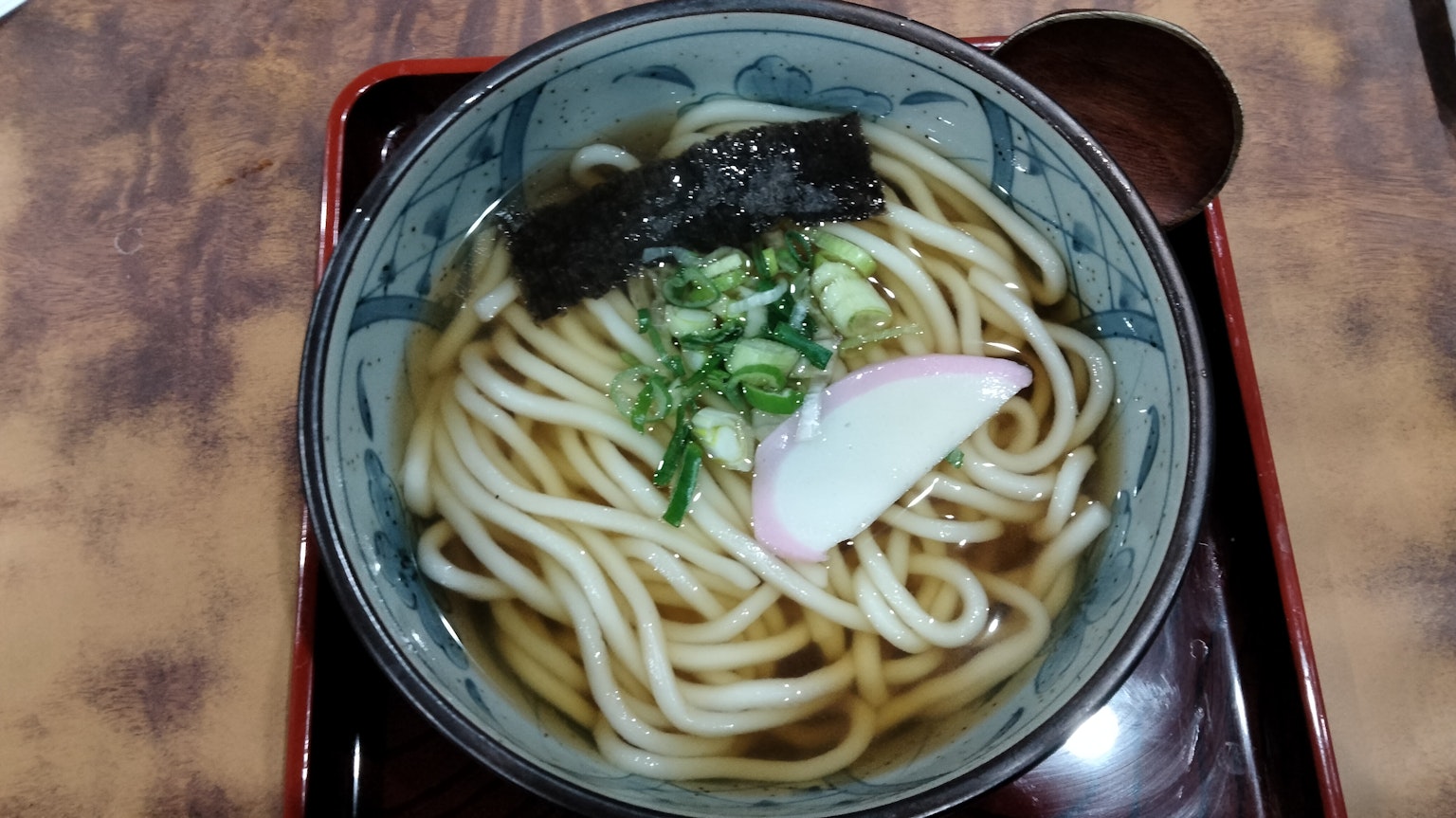 Tazón de fideos udon en caldo con cebollas verdes y kamaboko