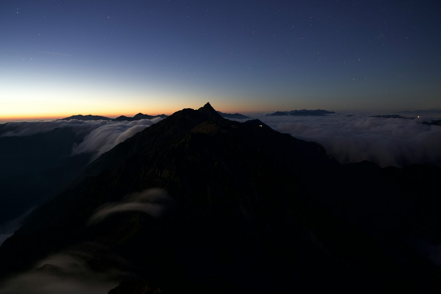 Silhouette of a mountain with a sea of clouds at dawn