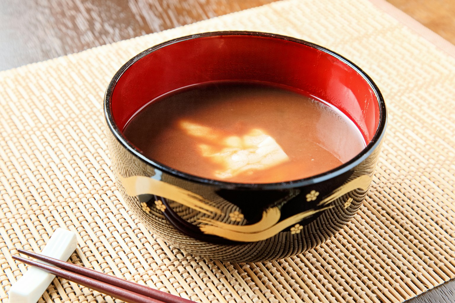 Sopa de miso servida en un hermoso tazón negro y rojo