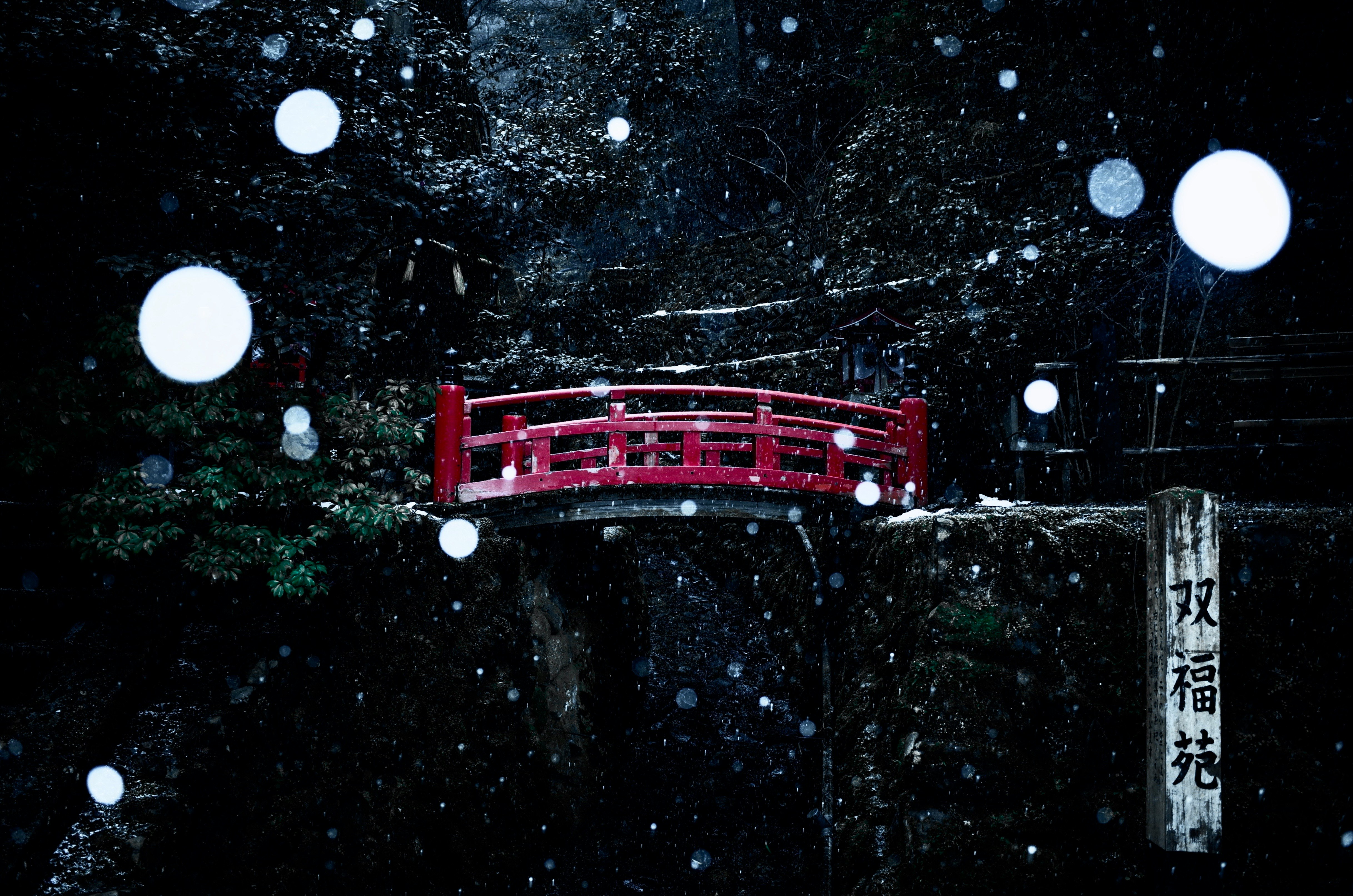 降る雪と赤い橋のある鞍馬山の参道