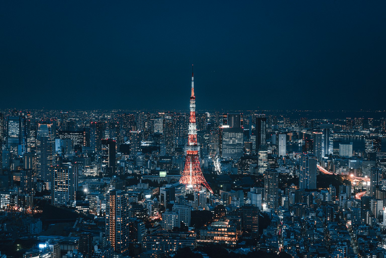 Tokyo Tower bei Nacht beleuchtet mit einer lebhaften Stadtsilhouette