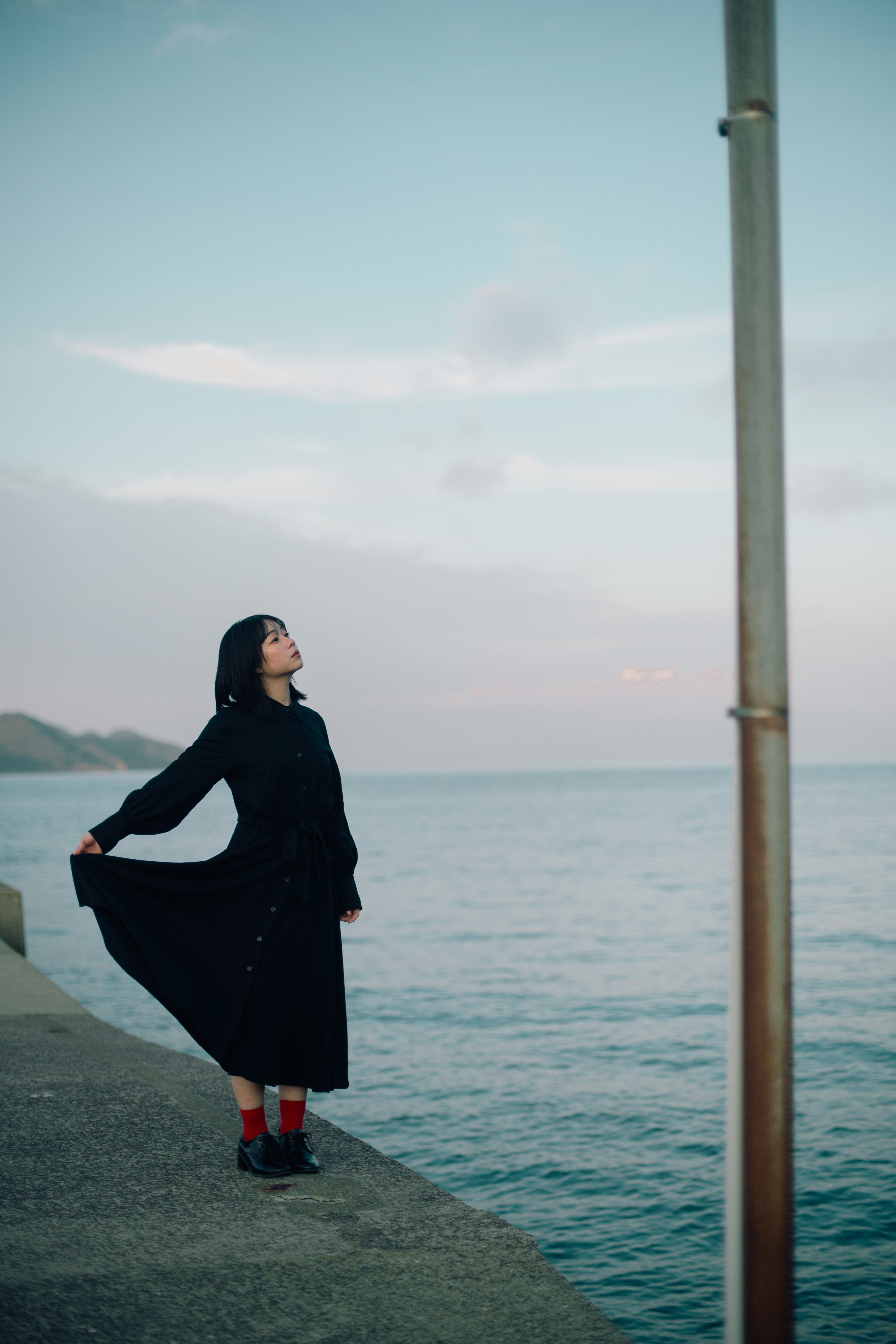 海辺の遊歩道でポーズをとる女性