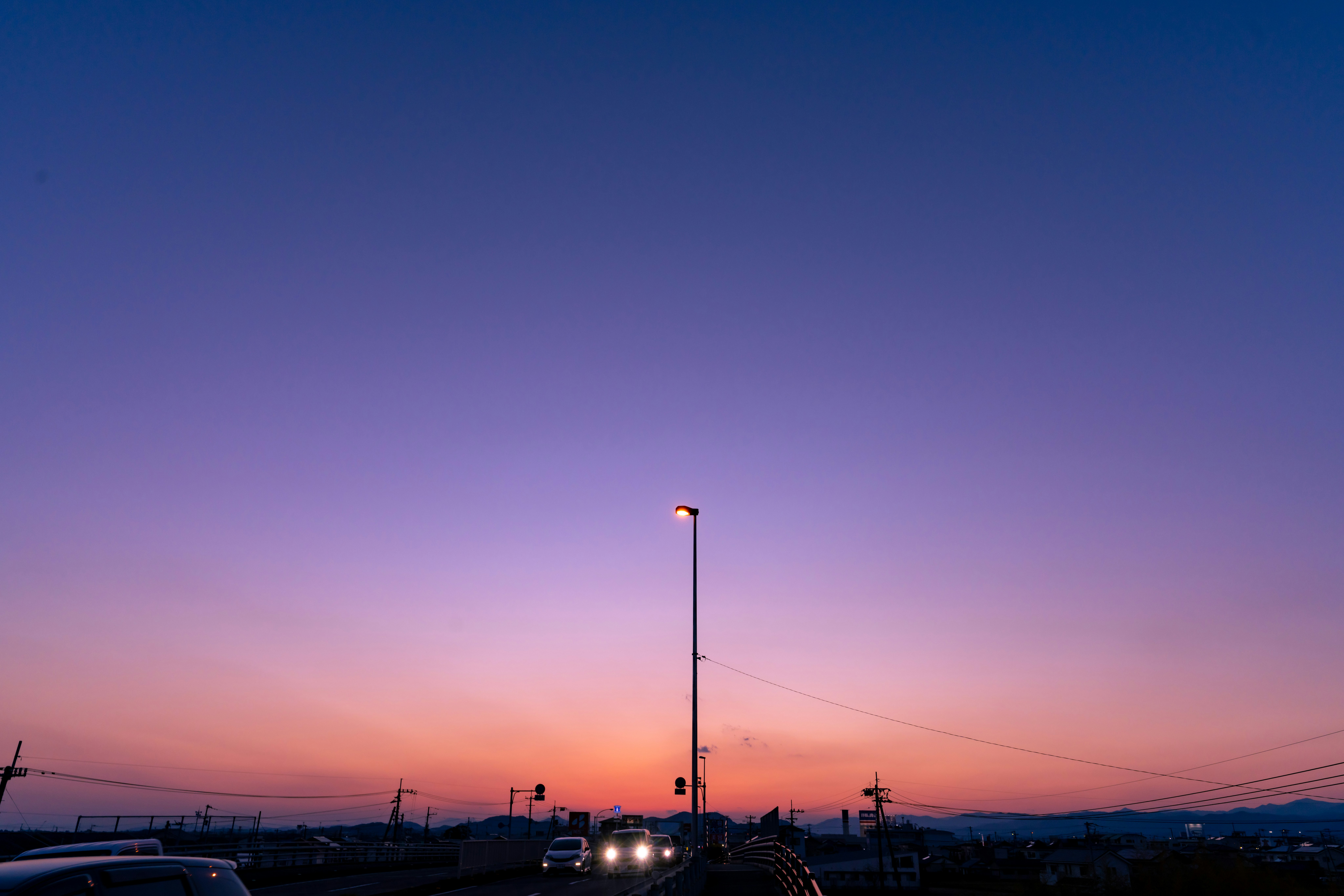 夕焼けの空と街灯のある郊外の道路風景