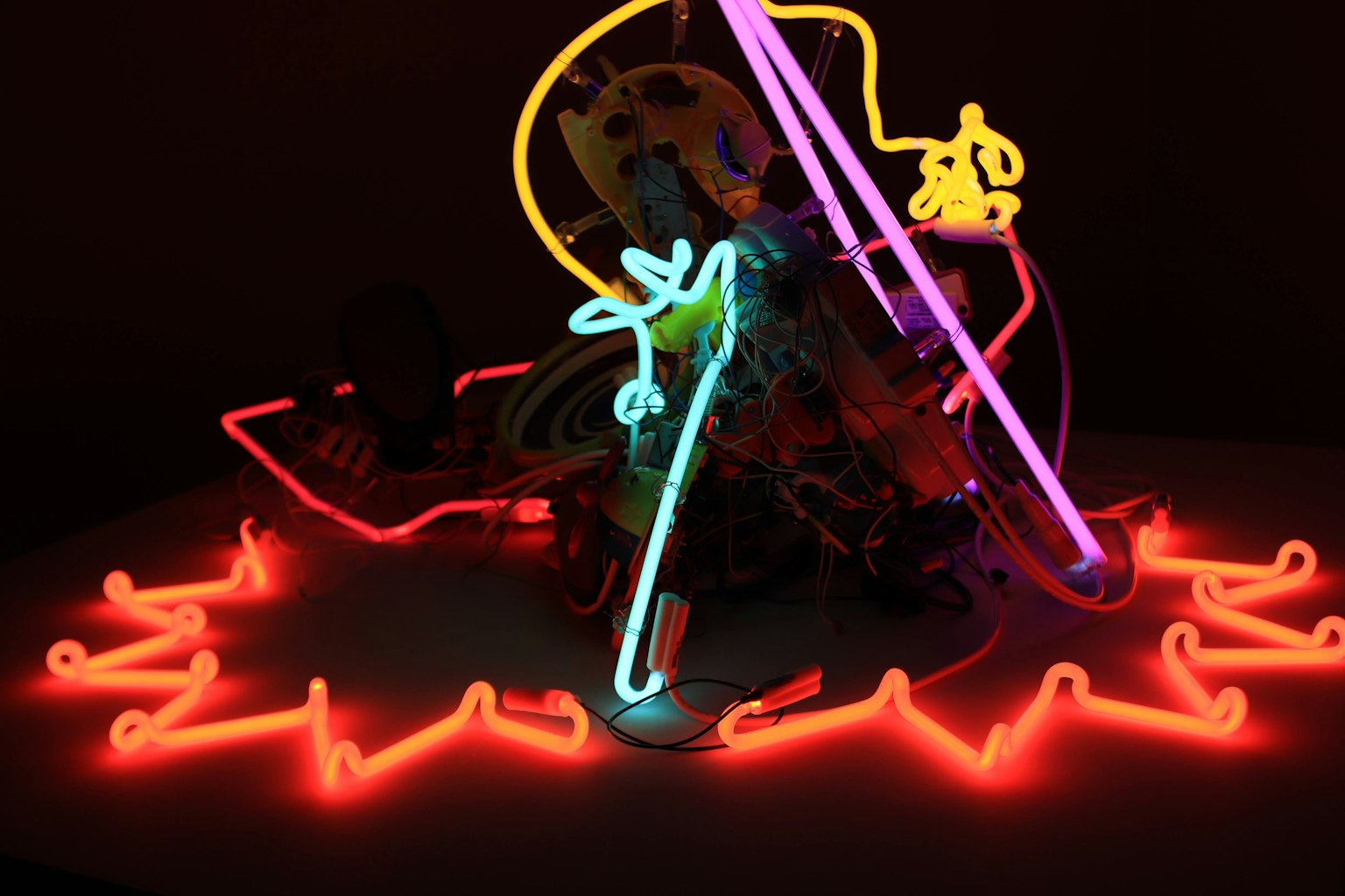 Luces de neón coloridas que se cruzan en una exhibición artística con tonos rojos y azules