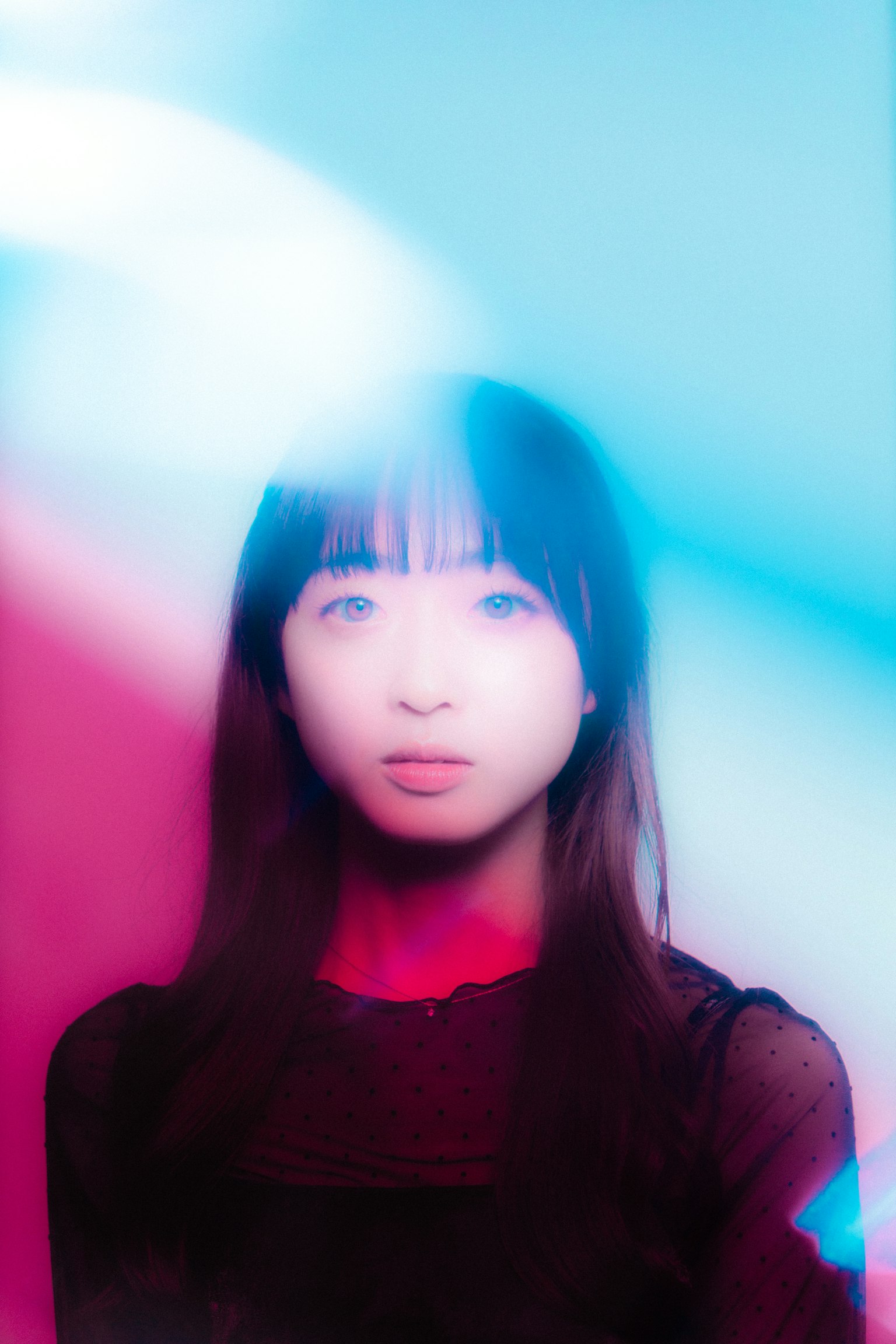 Retrato de una mujer envuelta en luz azul y roja