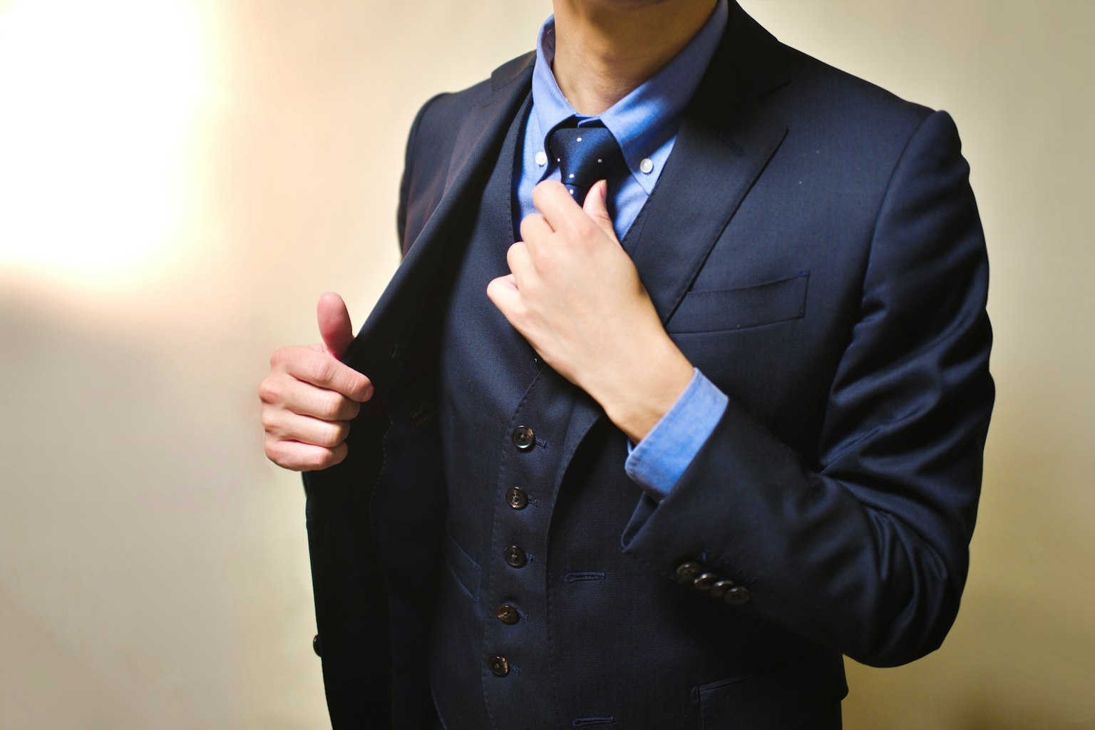 Man adjusting his tie while wearing a suit