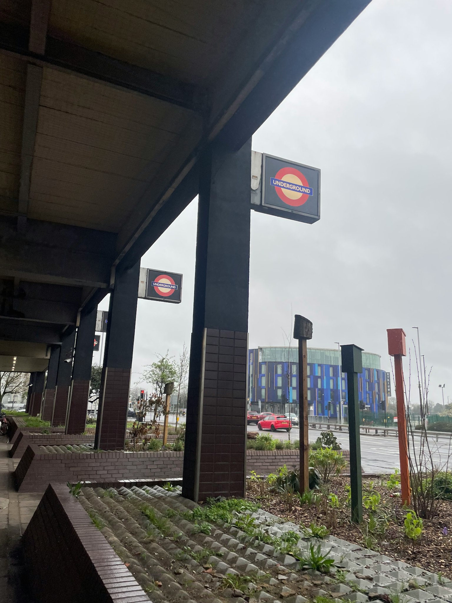 ทิวทัศน์ของสถานีรถไฟในวันที่มีฝนตกที่มีป้ายรถไฟใต้ดินลอนดอน
