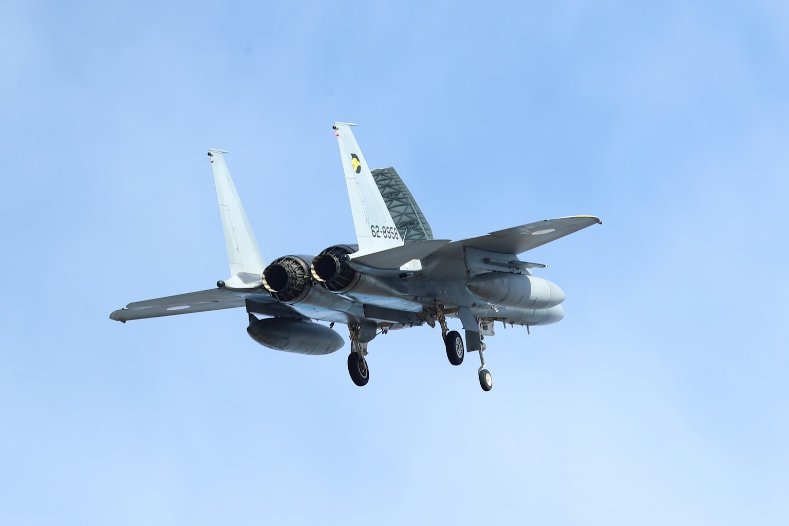 Caccia F-15 che vola contro un cielo blu visto da dietro