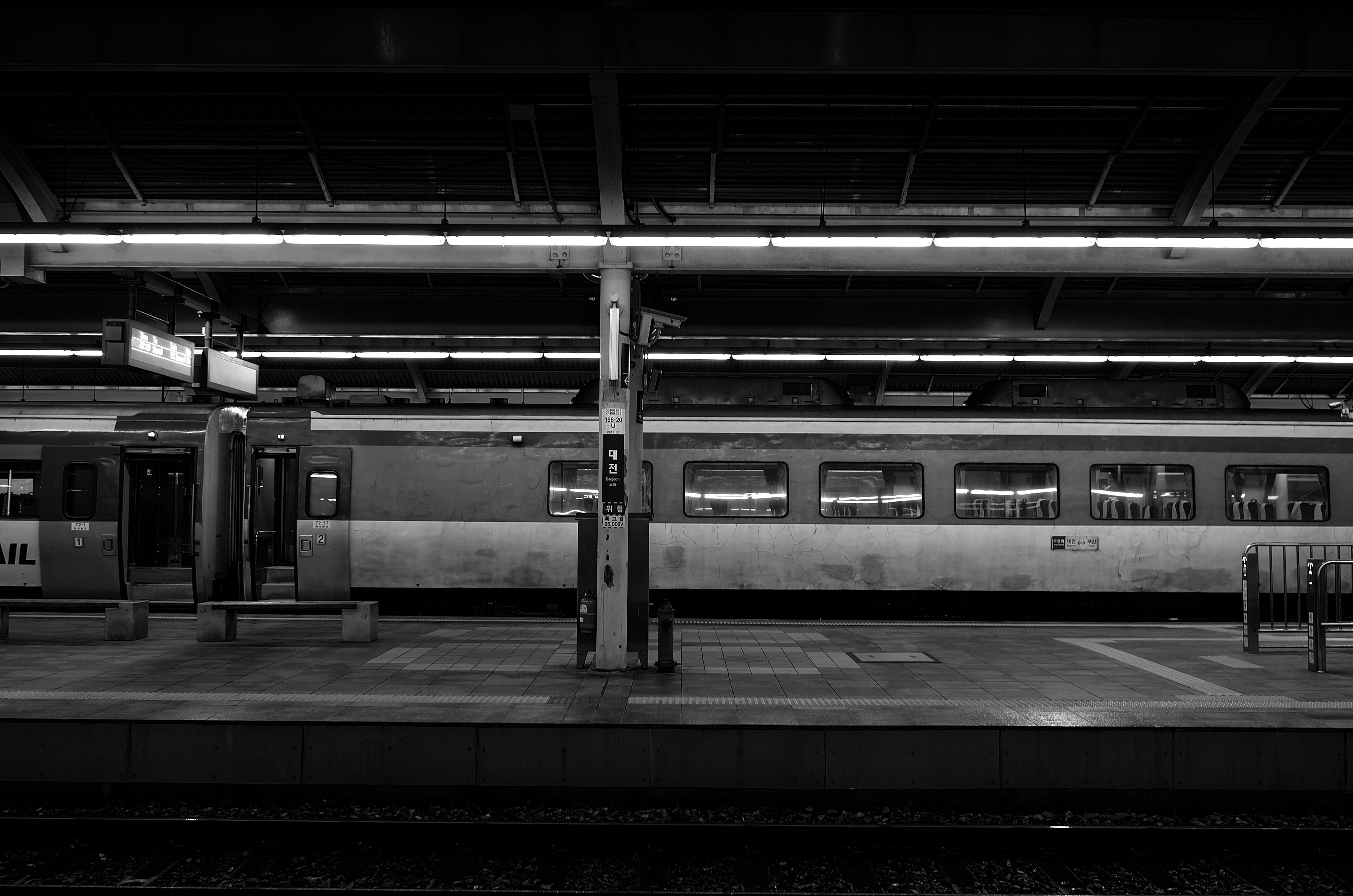 黒と白の駅のプラットフォームに停車中の列車と照明