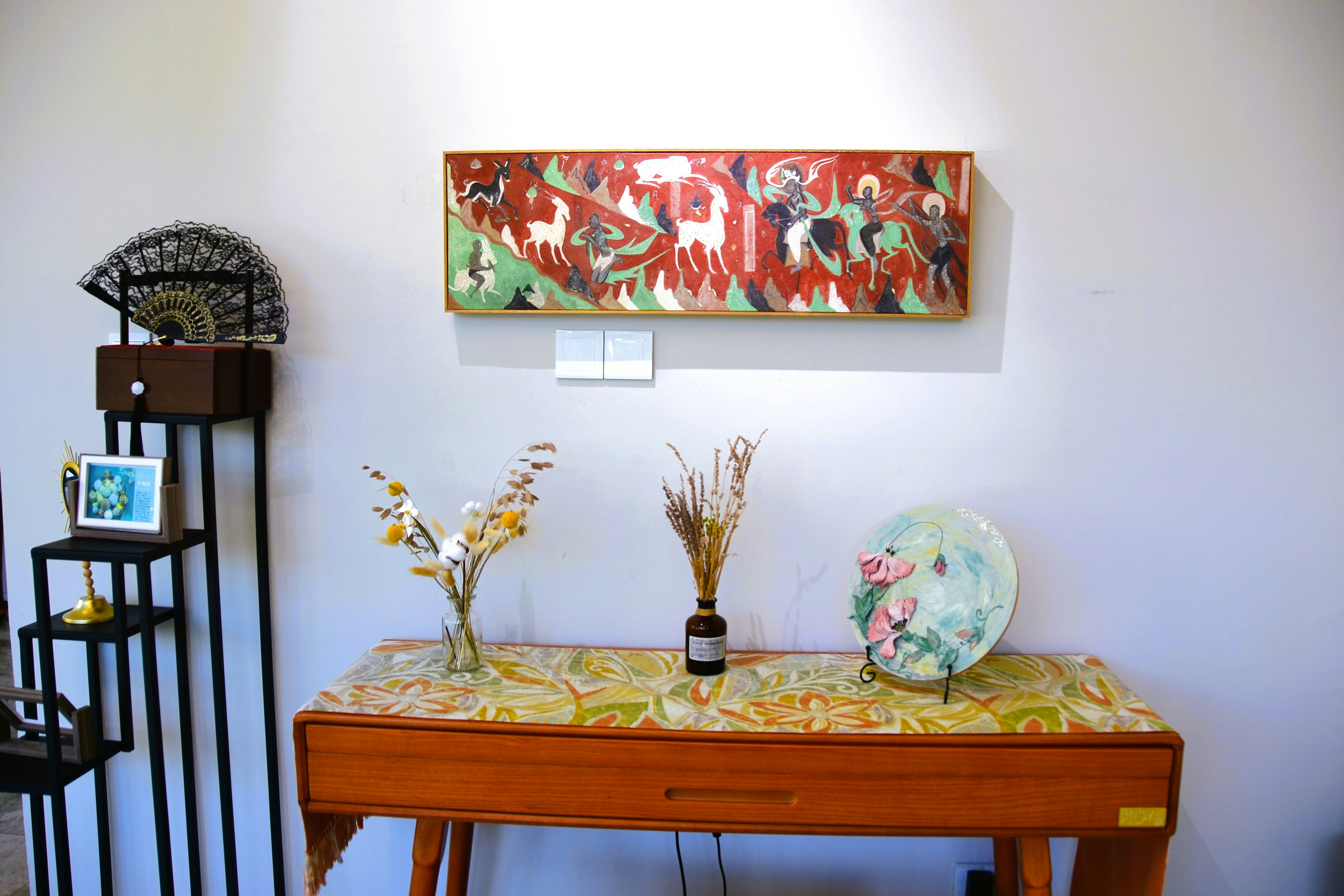 Indoor table with framed artwork and vases