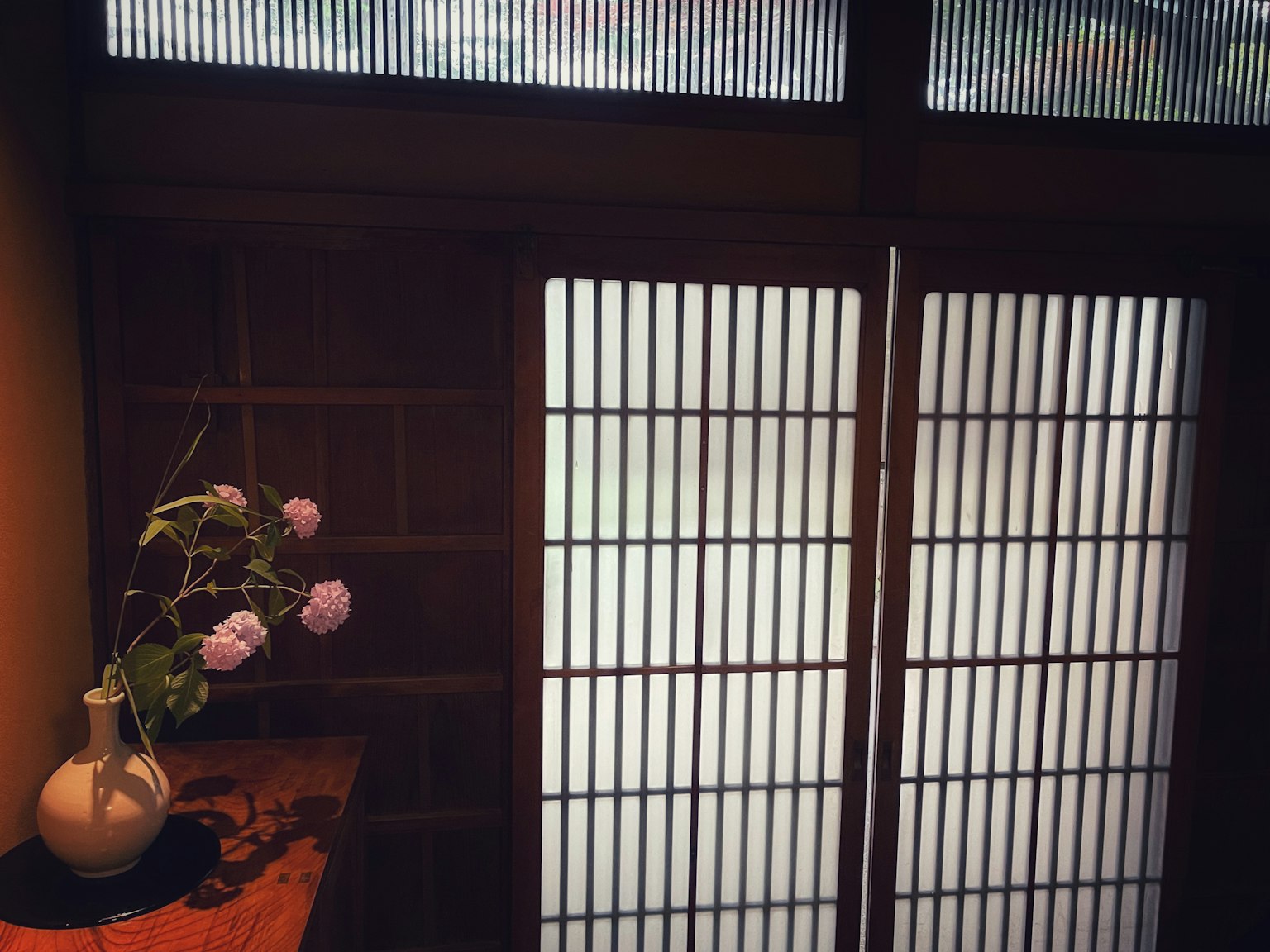 Interior view featuring shoji doors and a vase with flowers