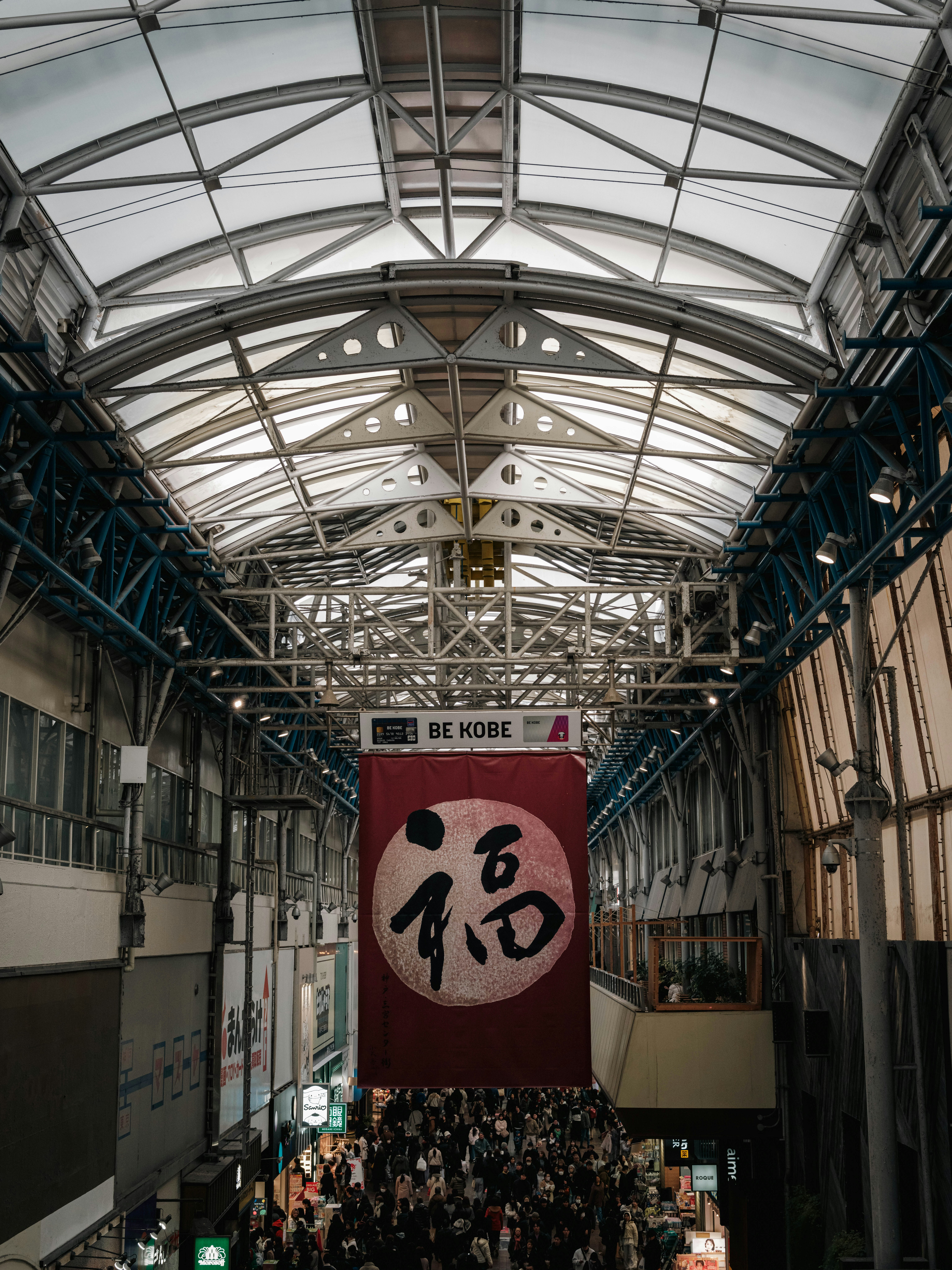神戸の屋内アーケードに掲げられた大きな看板と人の賑わい