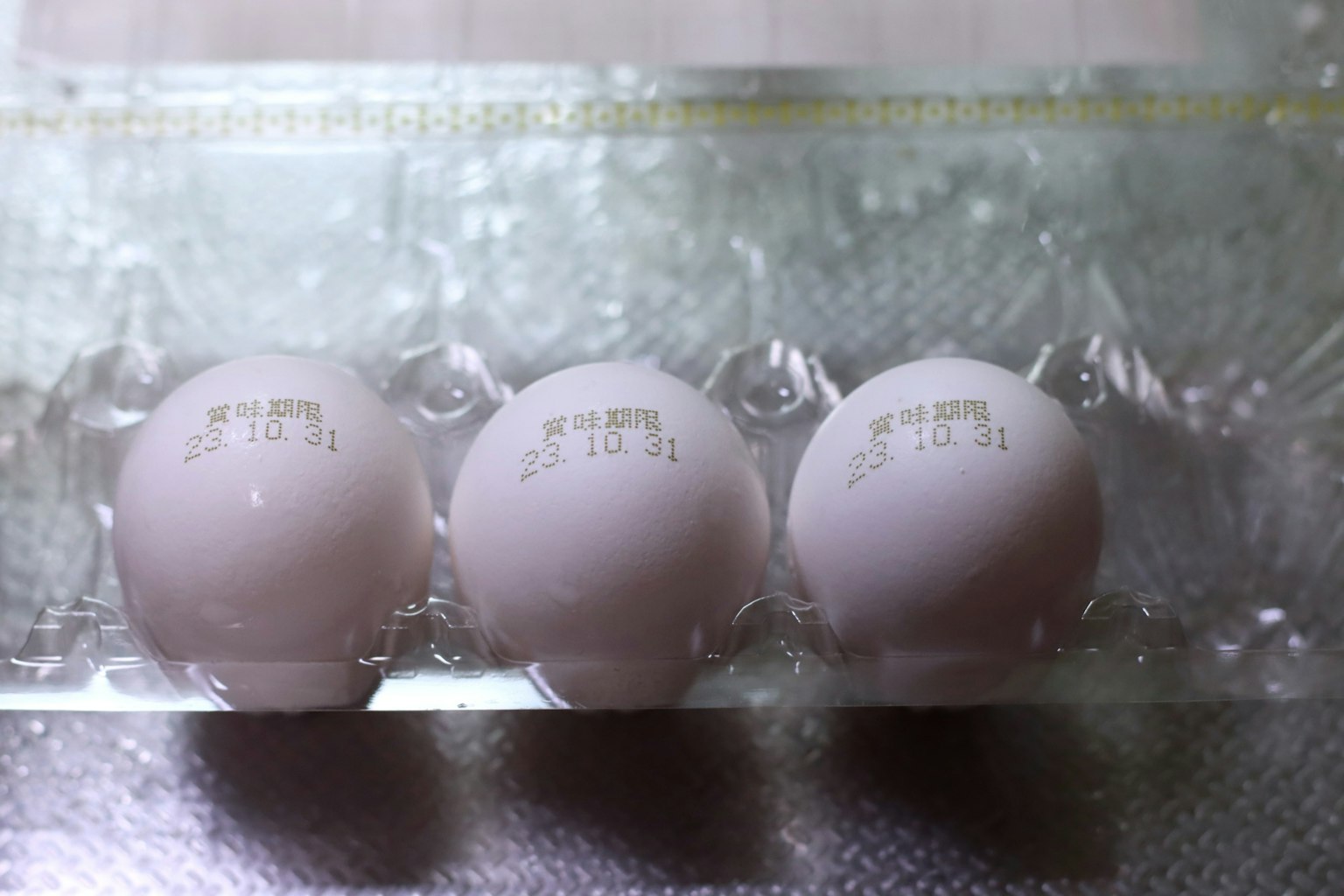 Tres huevos blancos en un cartón