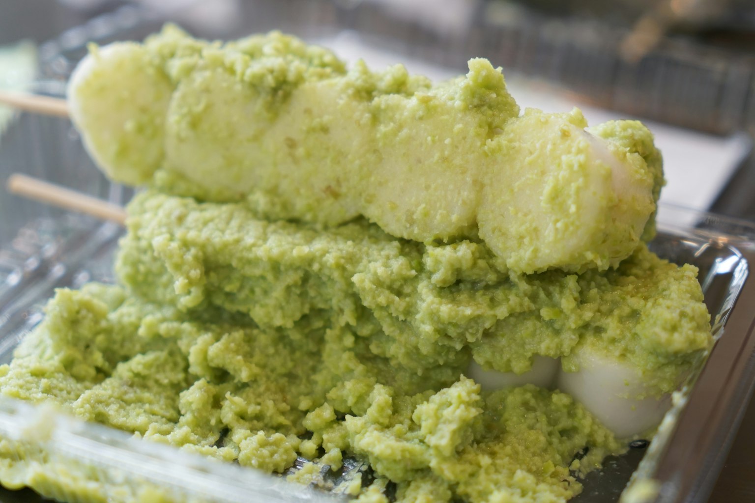 Puding dengan pasta matcha dan bola putih yang ditusuk