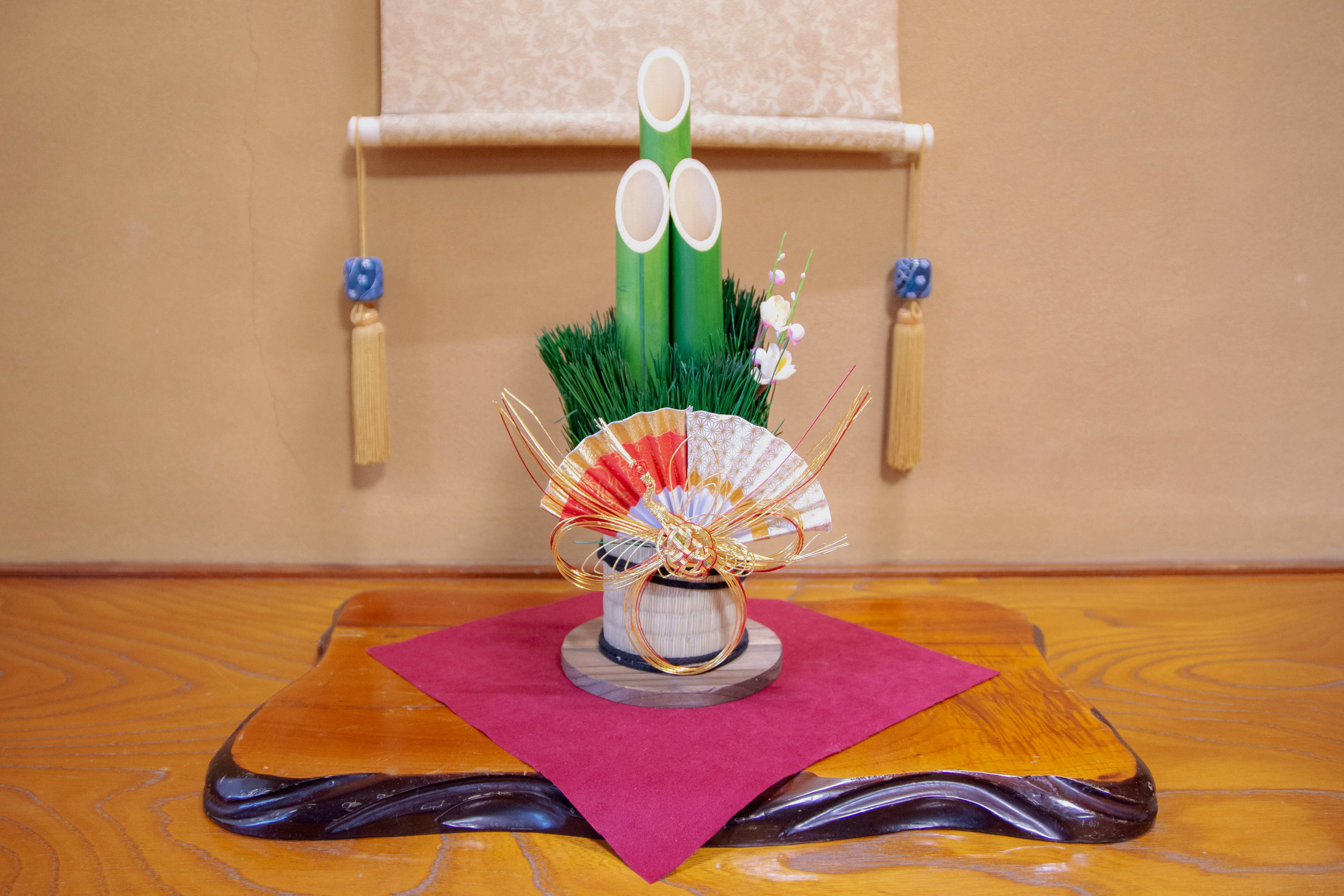 Éventail décoratif sur un chemin de table rose sur une table en bois