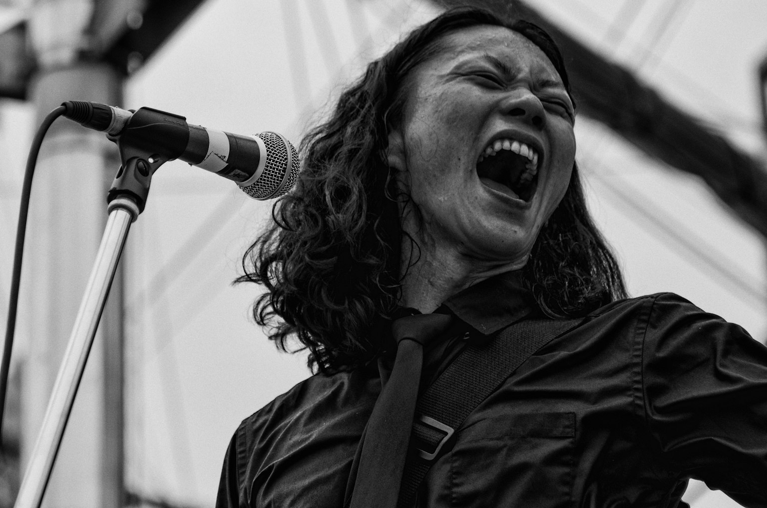 Un'immagine in bianco e nero di una donna che canta con passione in un microfono