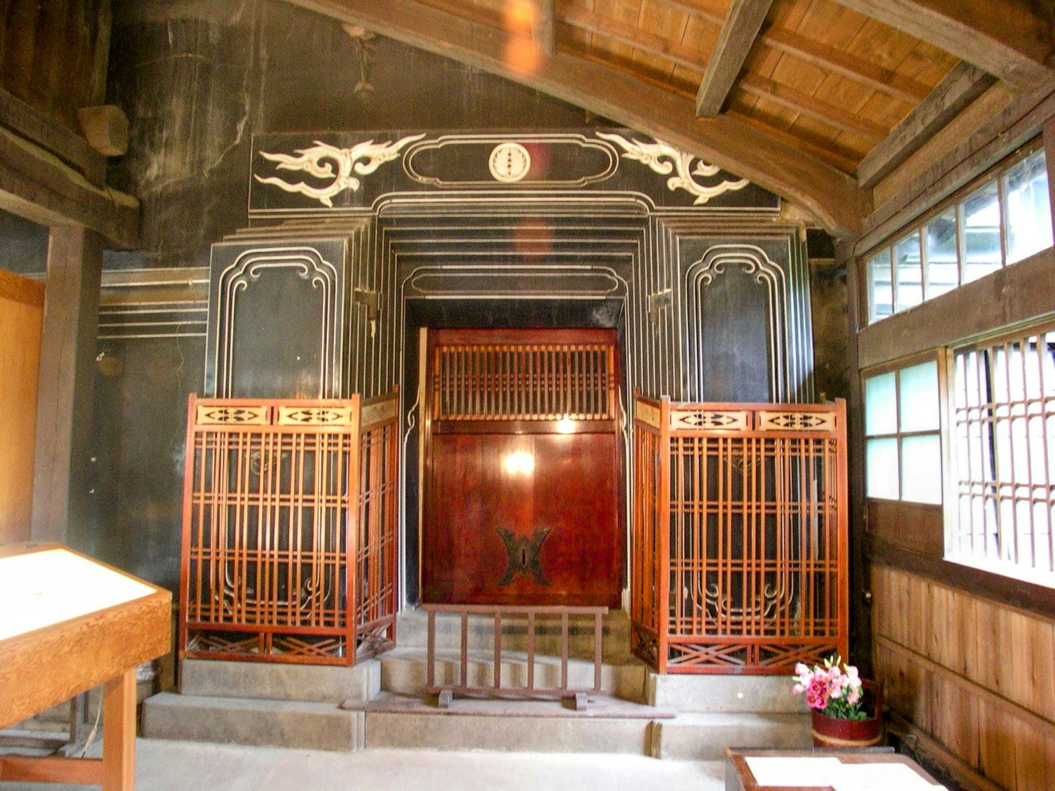 Intérieur d'un bâtiment japonais traditionnel avec des portes en treillis en bois et des murs ornés