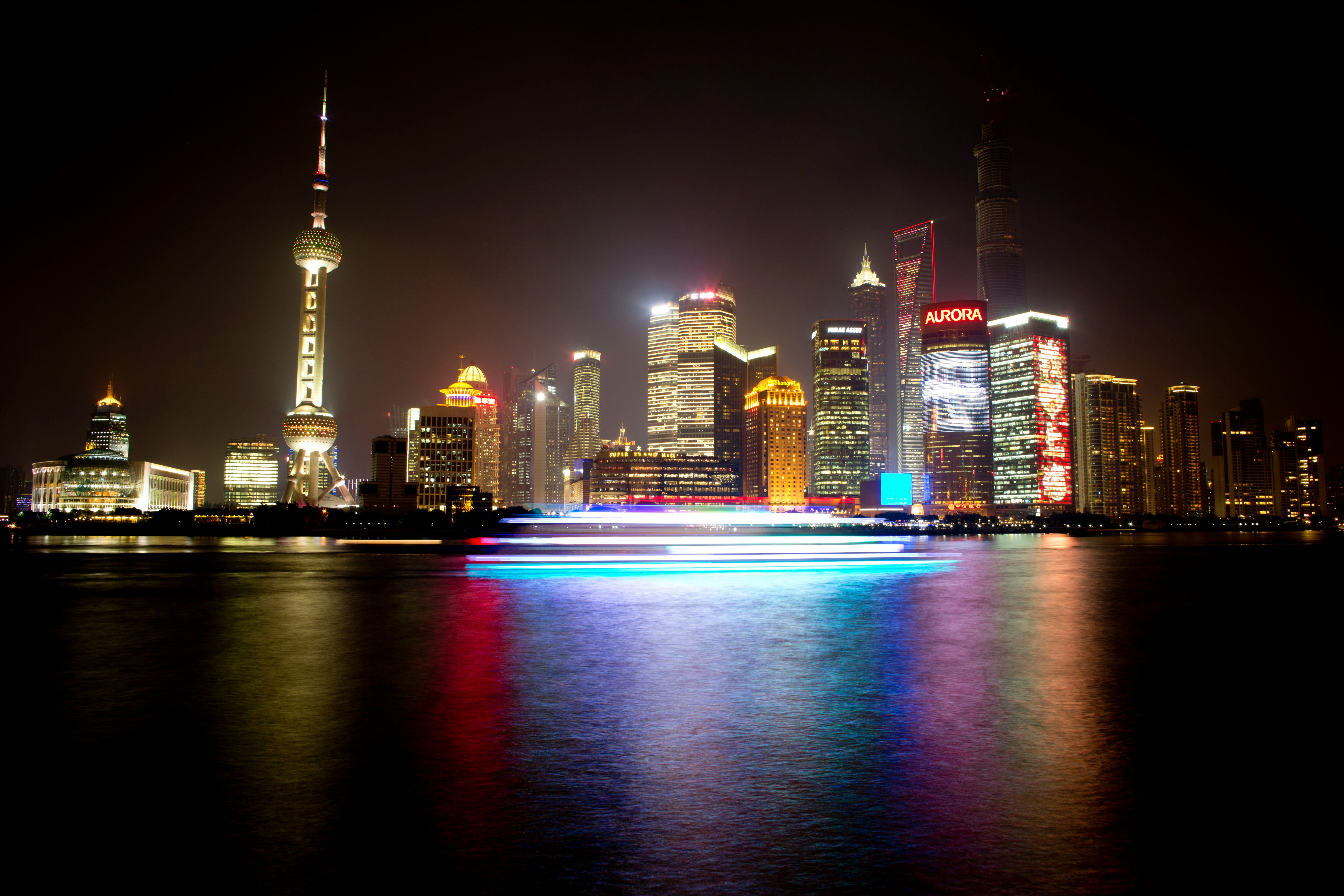 Vista nocturna del Bund de Shanghái con la torre de televisión y las luces del canal