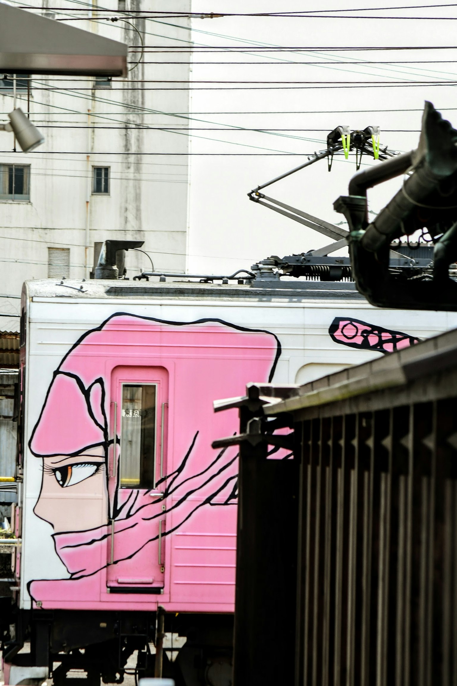 Treno con un personaggio ninja rosa sul lato e sfondo urbano