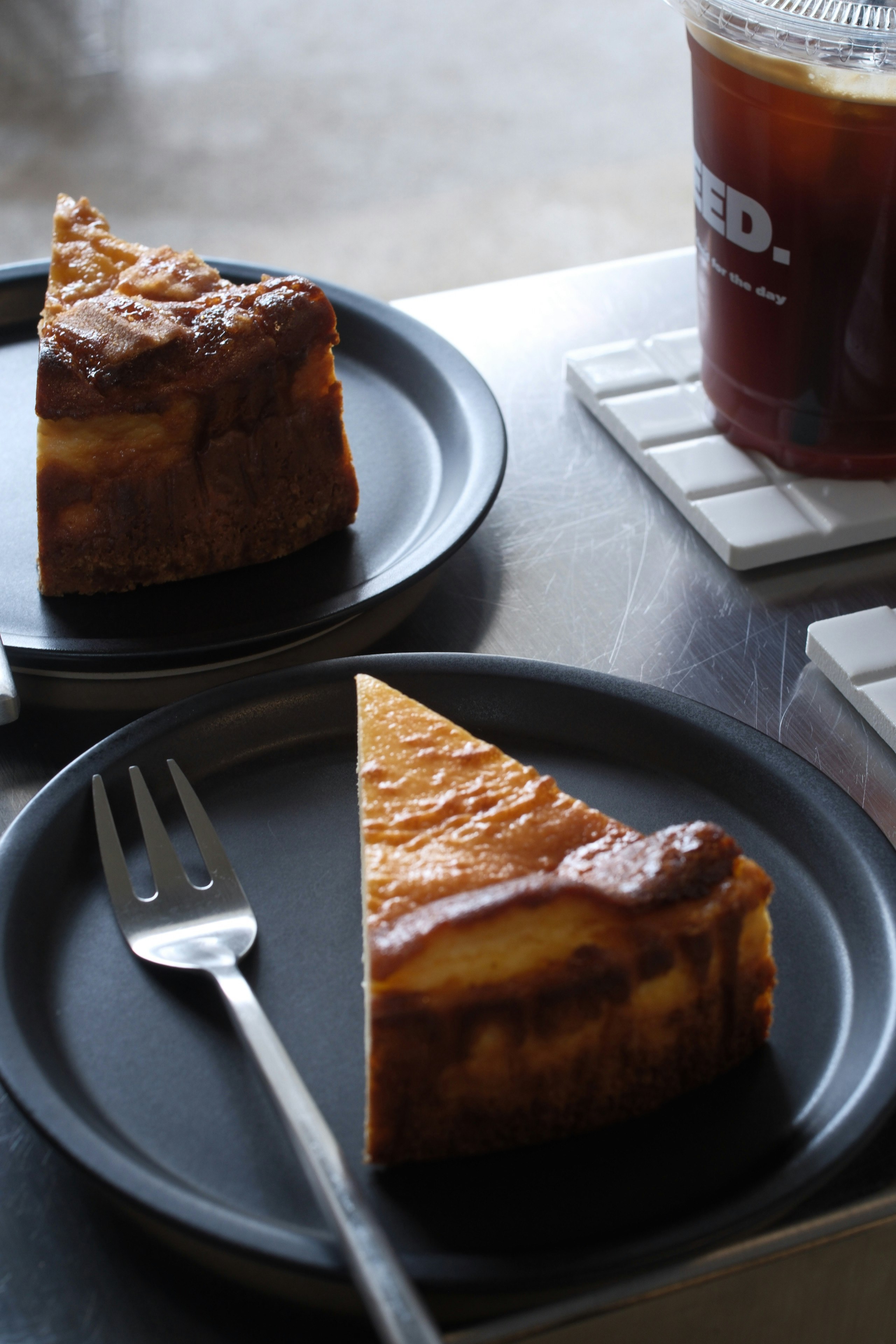 チーズケーキとコーヒーが並ぶカフェ店内のテーブル