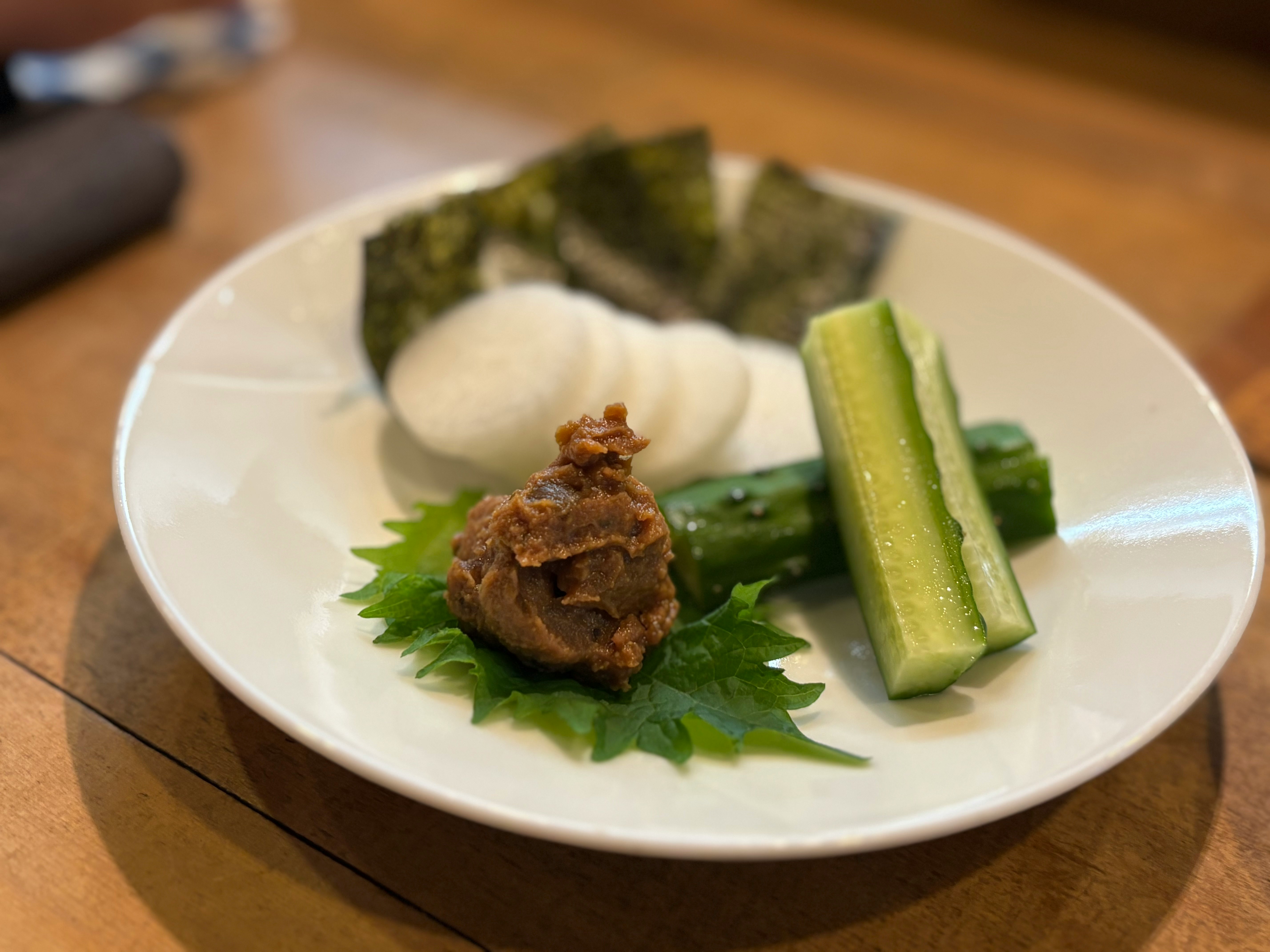 盘中味噌酱肉配黄瓜与葱花点缀