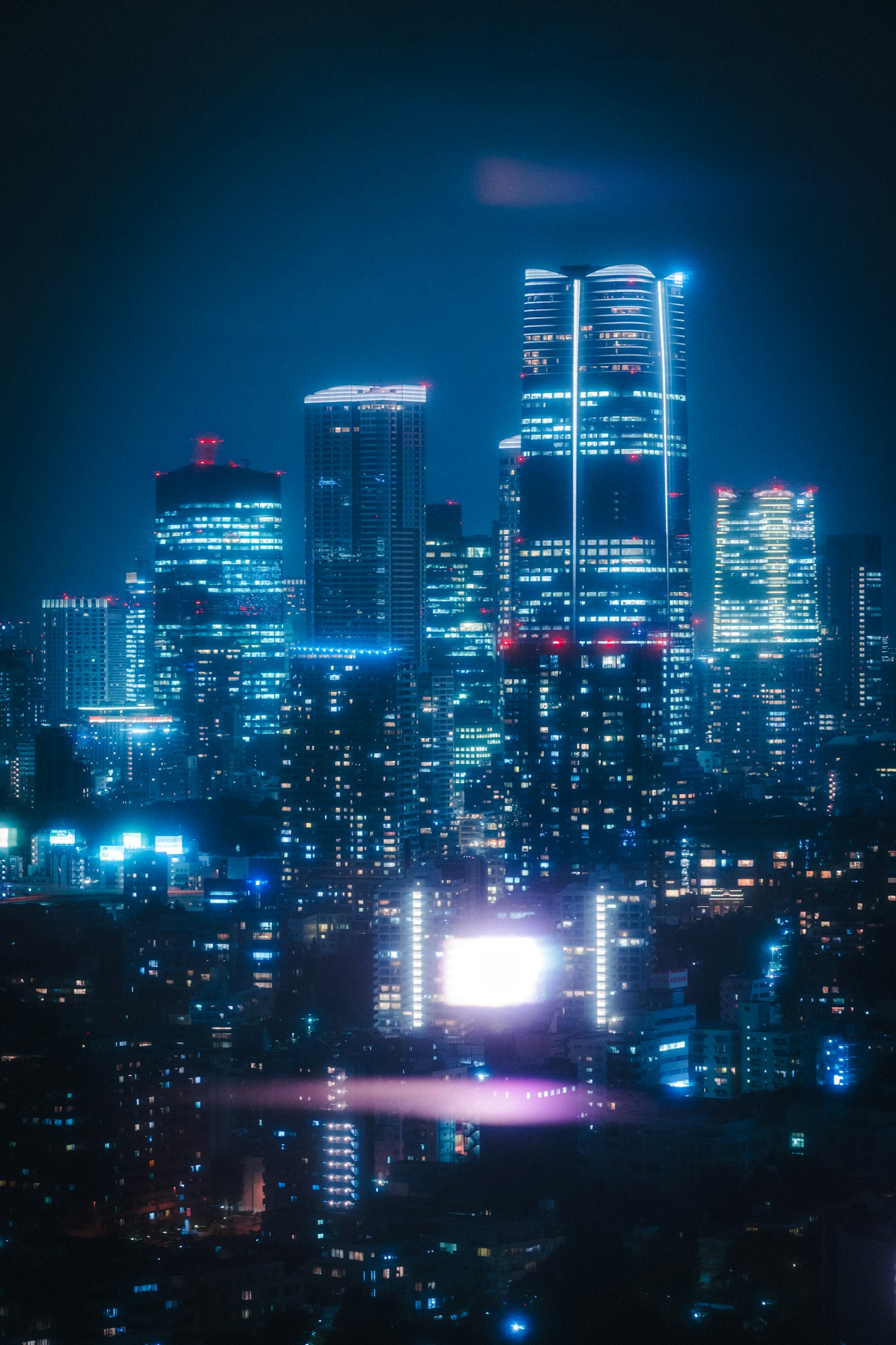 Stadtansicht bei Nacht mit blauen Lichtern und hohen Gebäuden